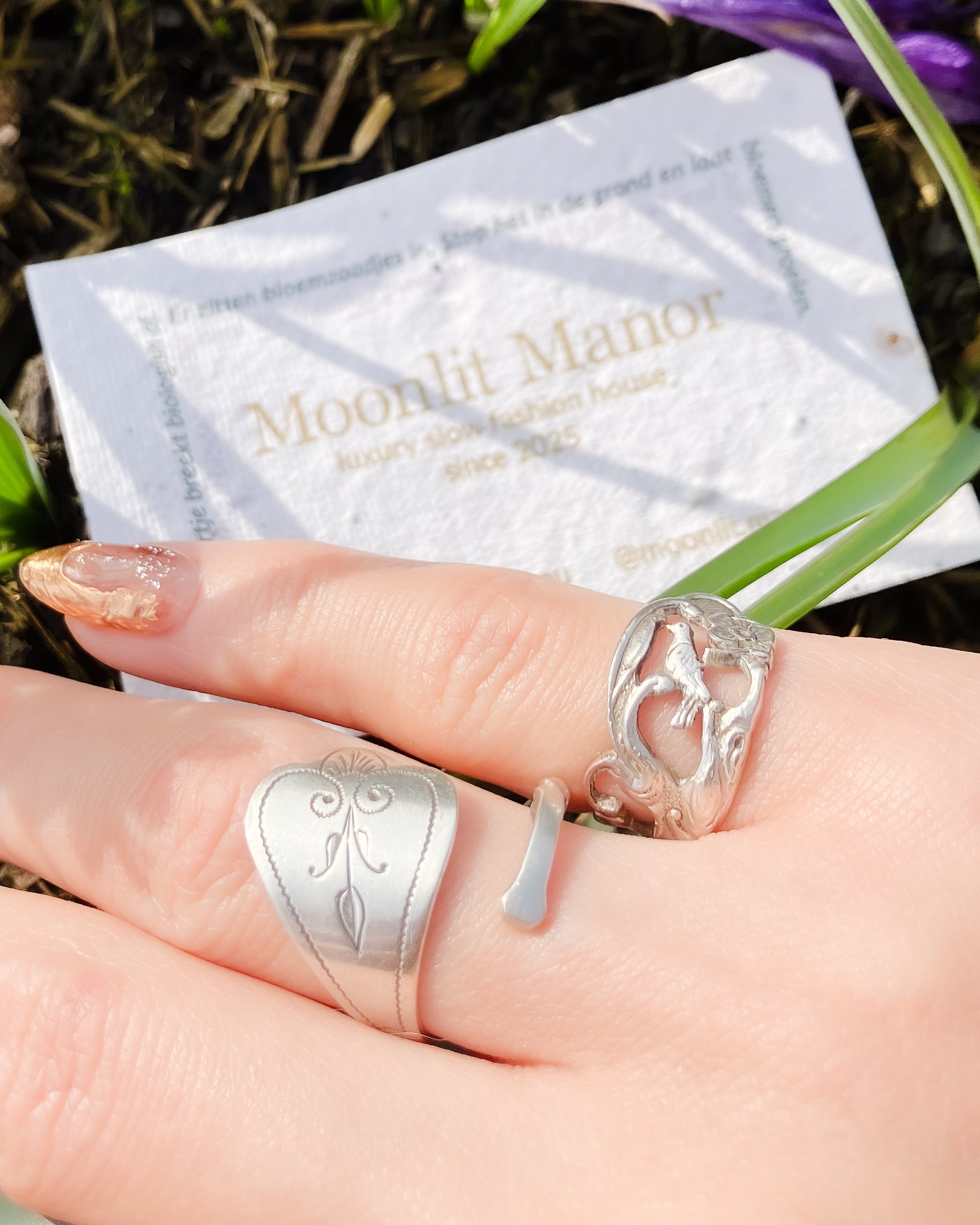 Vintage Dutch 925 sterling silver rings made from fork handles with openwork songbird and floral motif, handmade by Moonlit Manor Netherlands, on human hand with paper business card