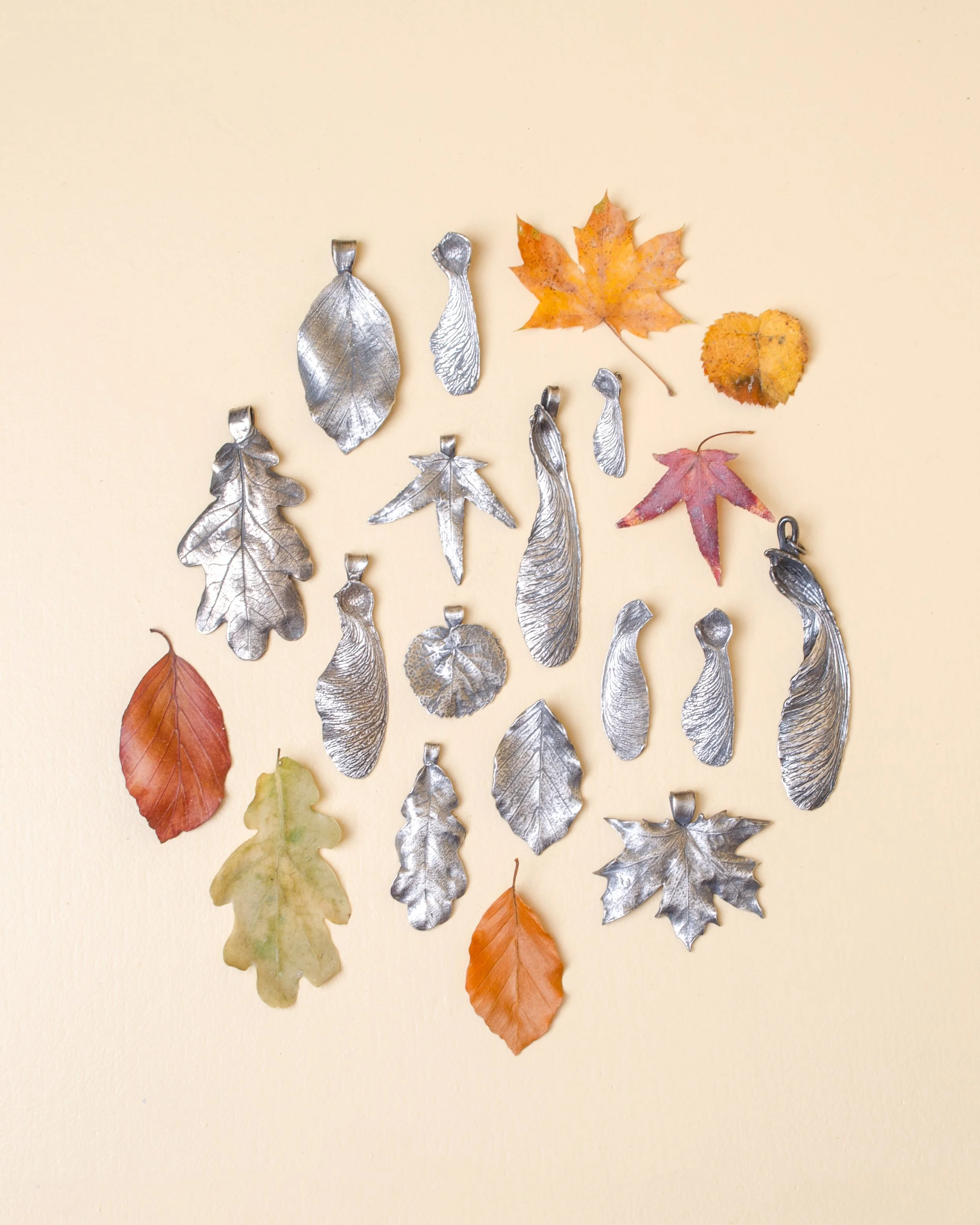 Handcrafted symbolic silver pendants inspired by nature, part of a luxury slow fashion jewelry collection