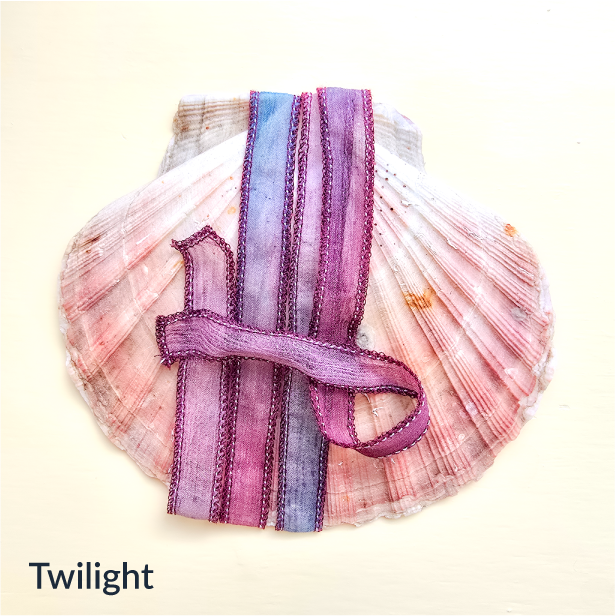 Upcycled Indian sari silk ribbon in rose, pink and champagne, draped on a pink scallop shell