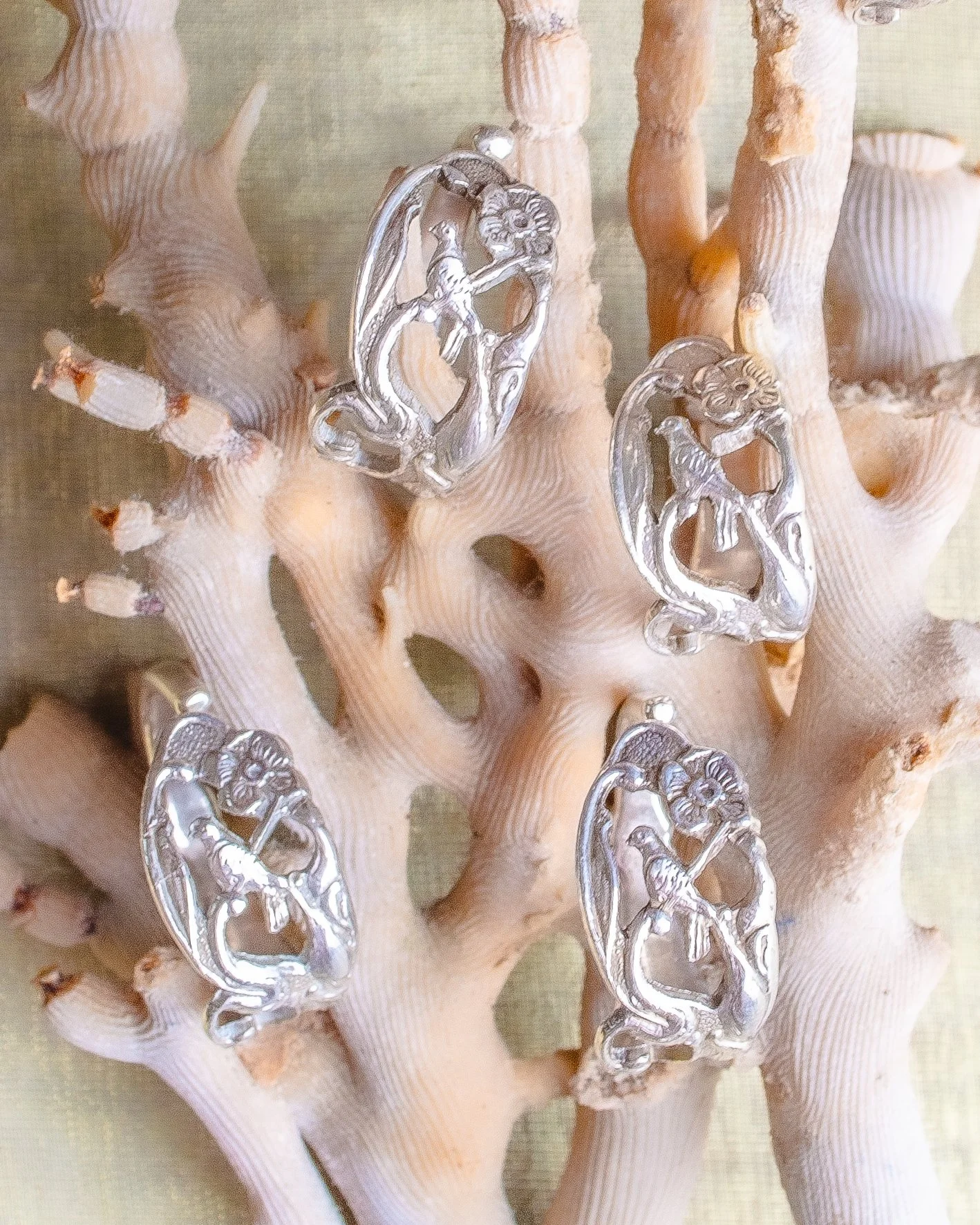 Vintage Dutch 925 sterling silver rings made from fork handles with openwork songbird and floral motif, handmade by Moonlit Manor Netherlands, on white coral