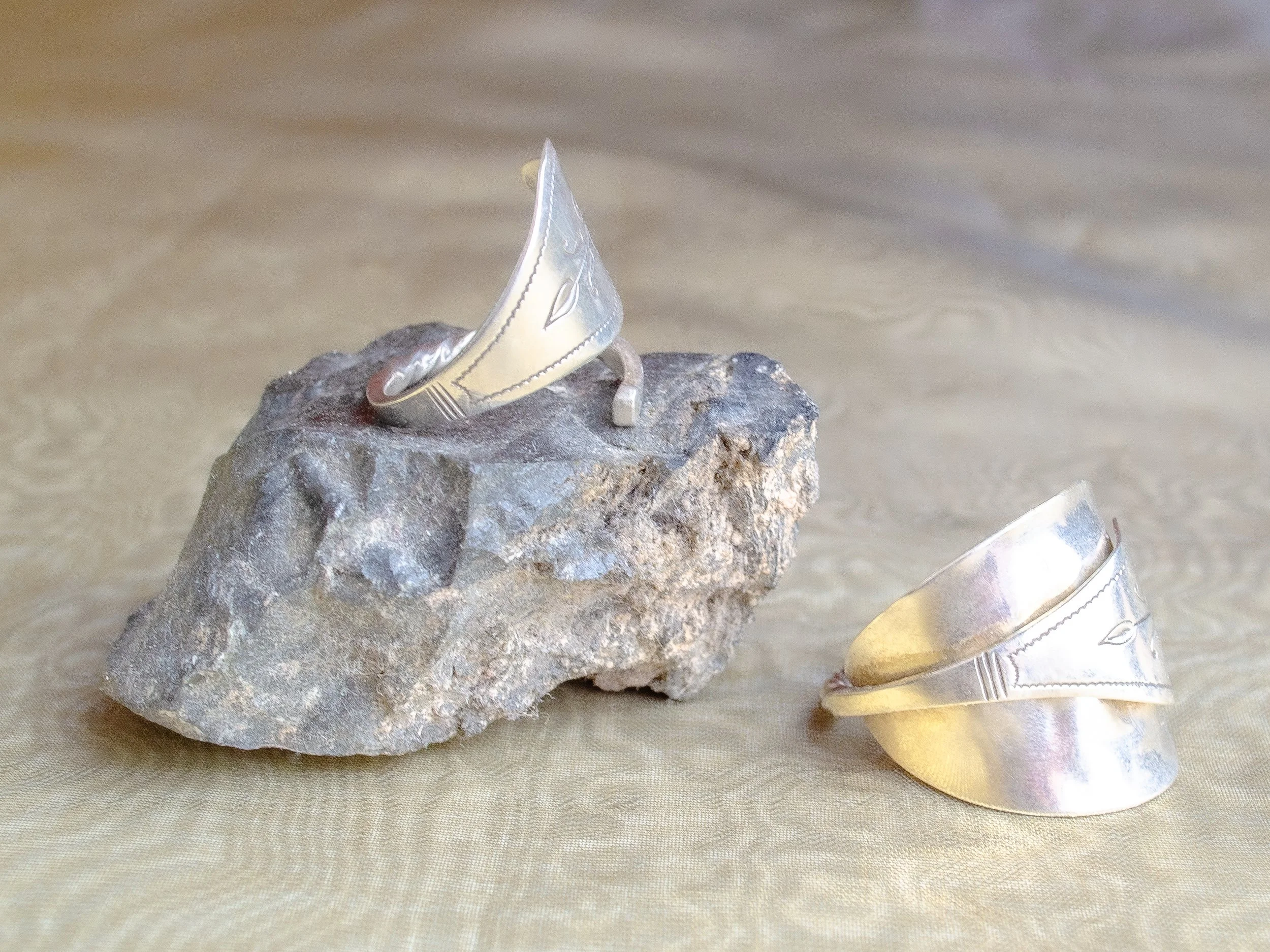 Two vintage Dutch 925 sterling silver heart spoon rings handmade by Moonlit Manor Netherlands, heart-shaped bowl motif with Art Nouveau engraving, on grey stone