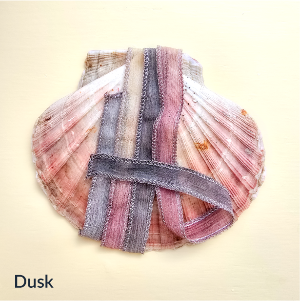 Upcycled Indian sari silk ribbon in grey, mauve and blush, draped on a pink scallop shell