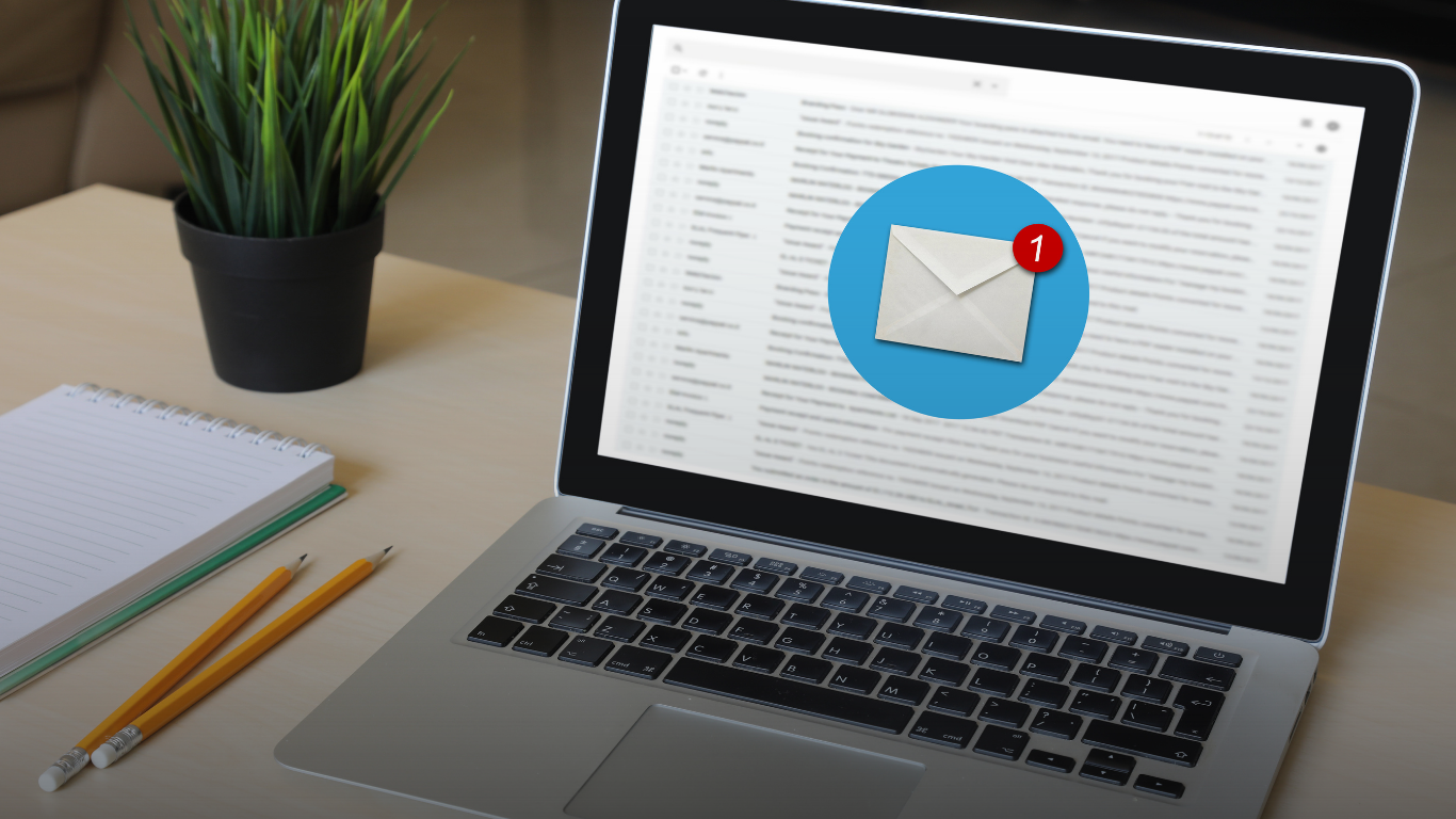 Laptop on a desk displaying an email notification icon with one new message