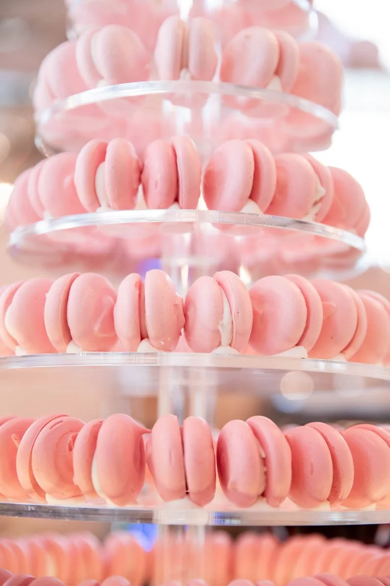 Pink macarons displayed on a tiered stand.