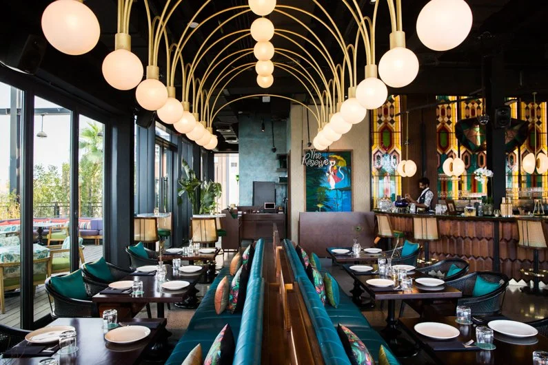 Upscale interior of Masti restaurant with modern lighting, colorful decor, and neatly arranged tables set for dining.