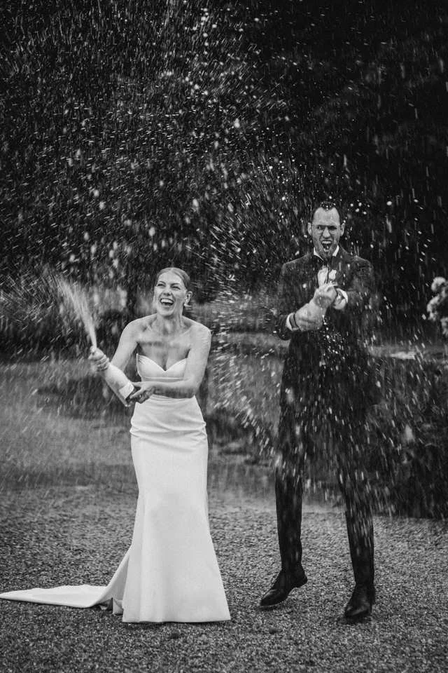 Ein Paar in formeller Kleidung, das auf einer Feier mit Sekt und Champagner feiert.