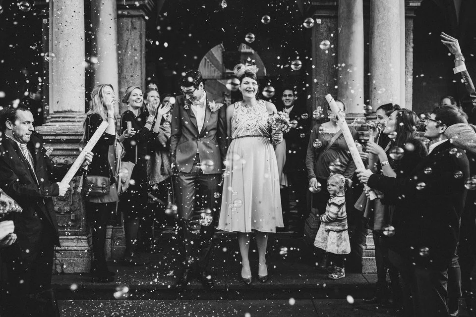 Paar verlässt das Standesamt, von Freunden mit Seifenblasen gefeiert