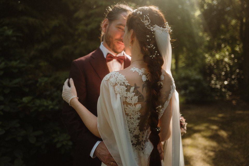 Ein Brautpaar bei einer Besiegelung ihrer Liebe im Freien bei Sonnenuntergang, umgeben von Natur.