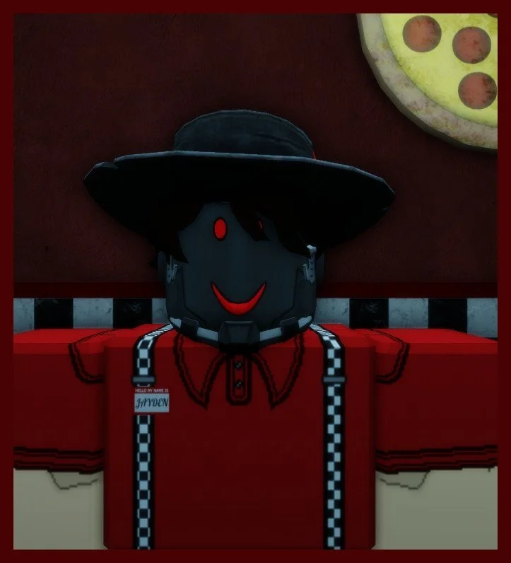 Lifelike humanoid figure with a black face, red eyes, and a red smile, wearing a black wide-brimmed hat and a red shirt with black suspenders, posed in front of a dark background with a pizza sign in the top right corner.
