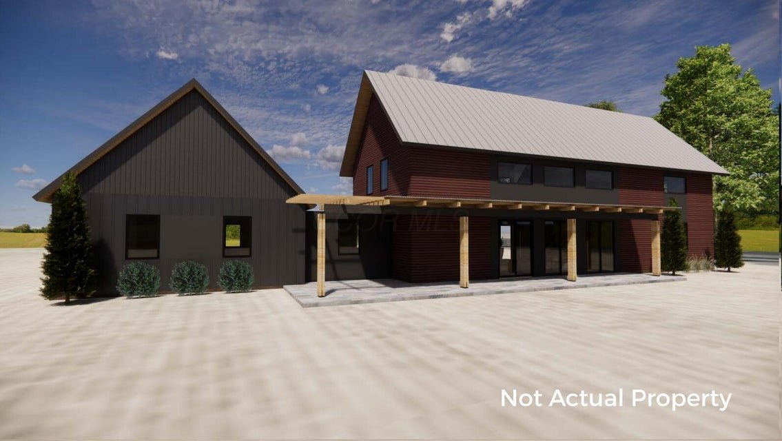 Modern two-story house with black and red siding, metal roof, large windows, surrounded by green lawn and trees, with a wood deck on the upper level, under a clear sky.
