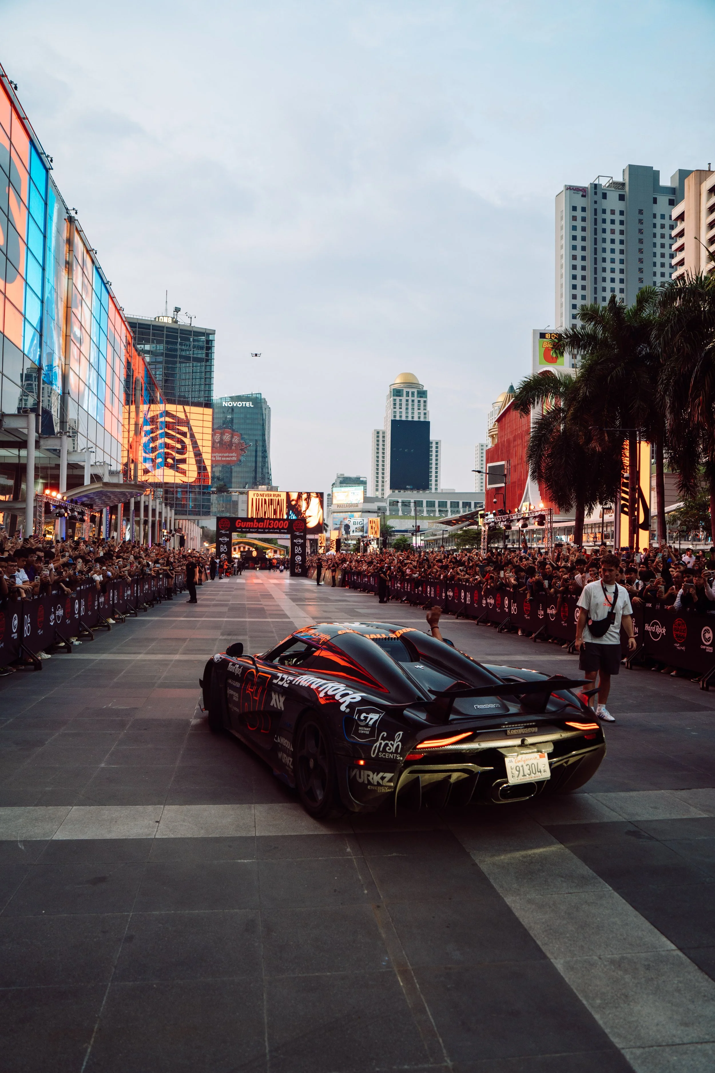 Cars begin to arrive into Bangkok, welcome by thousands of fans