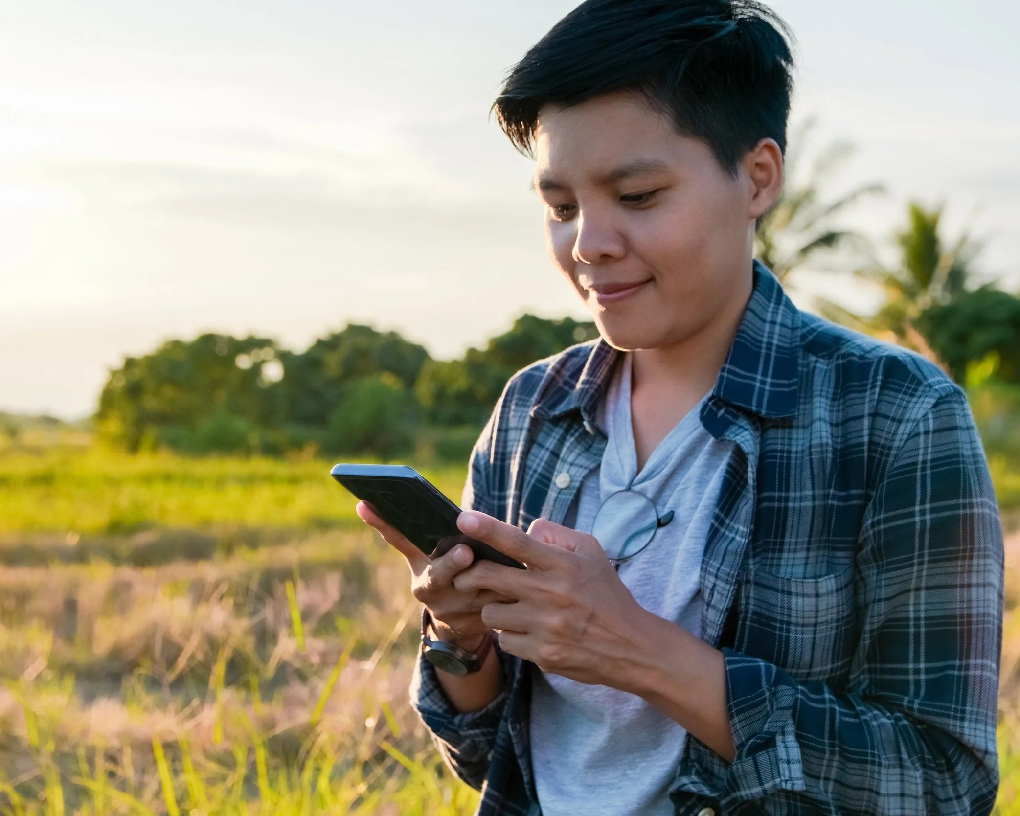 Person looking at their phone in a field