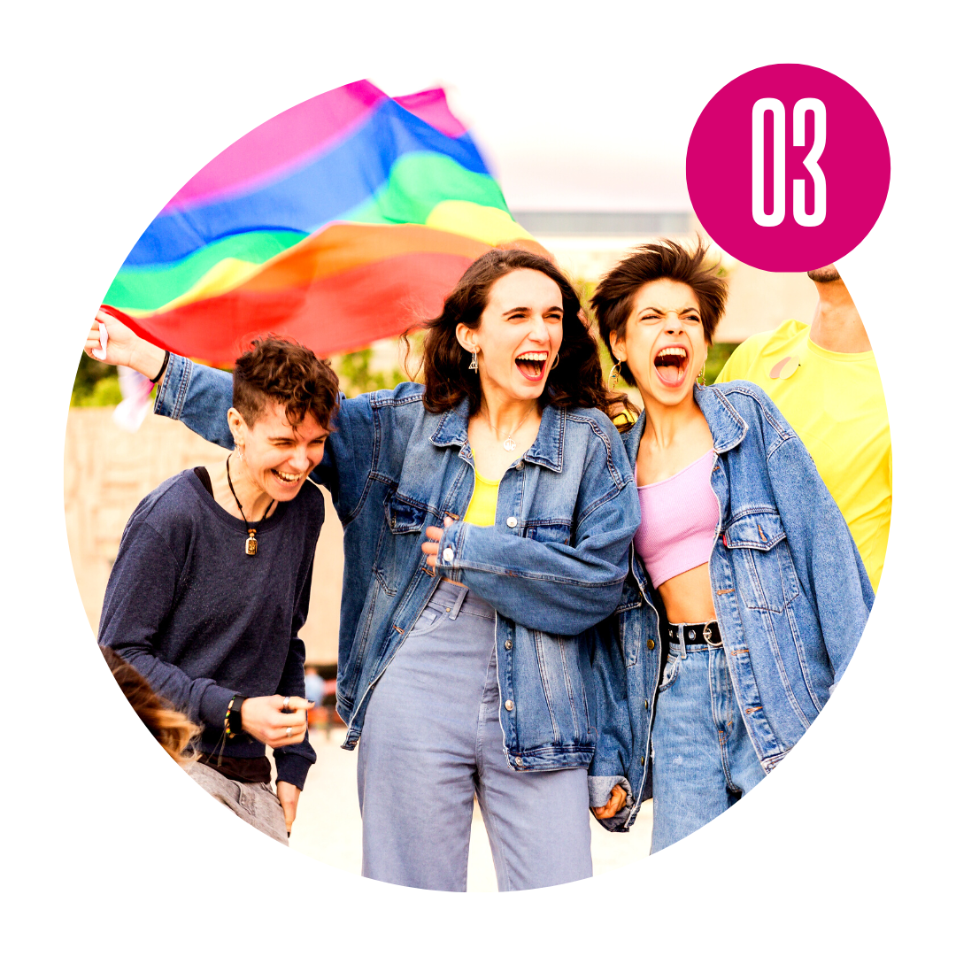 Three young queer people holding a rainbow flag and laughing.