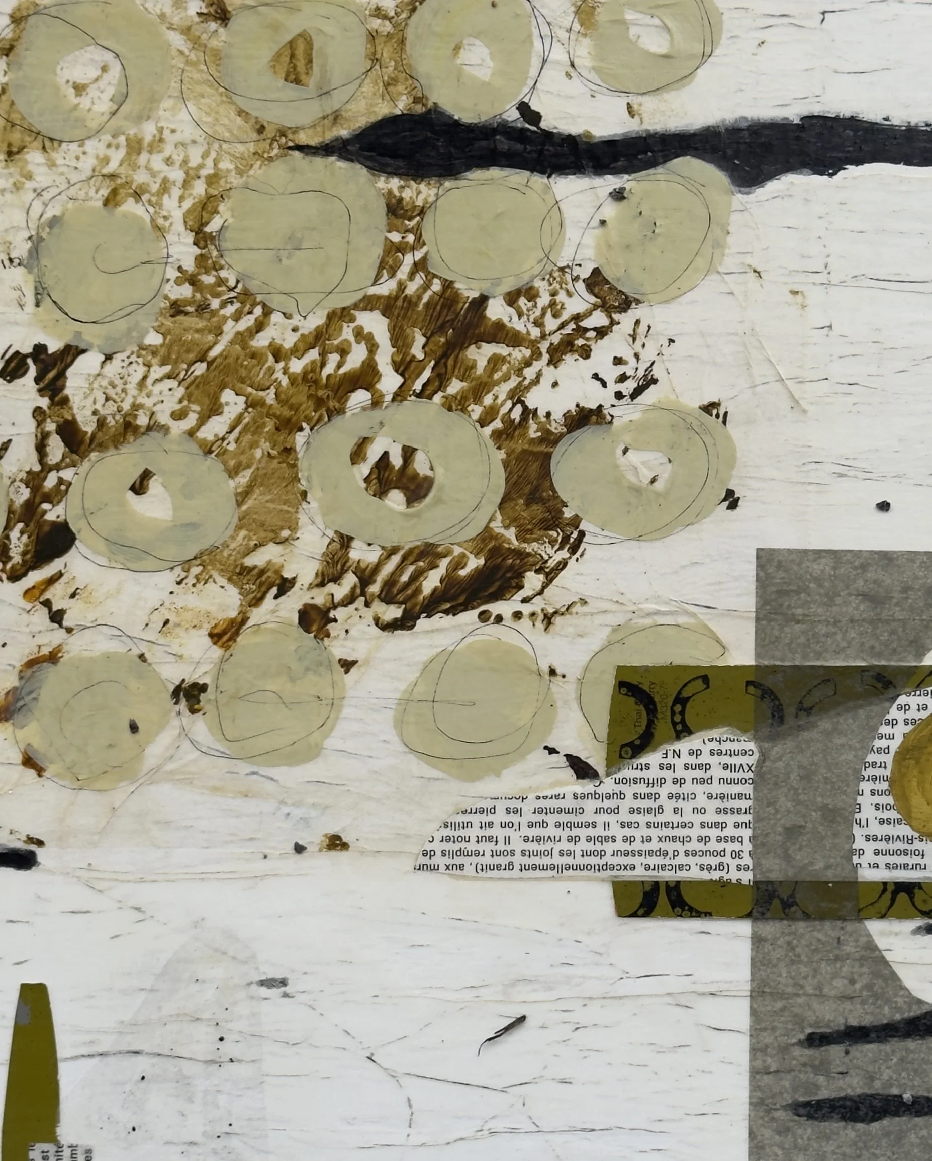 Une surface en bois blanc avec des traces de peinture ou de scav en brun et noir, recouverte partiellement de morceaux de papier avec des textes en français et quelques cercles en papier translucide.