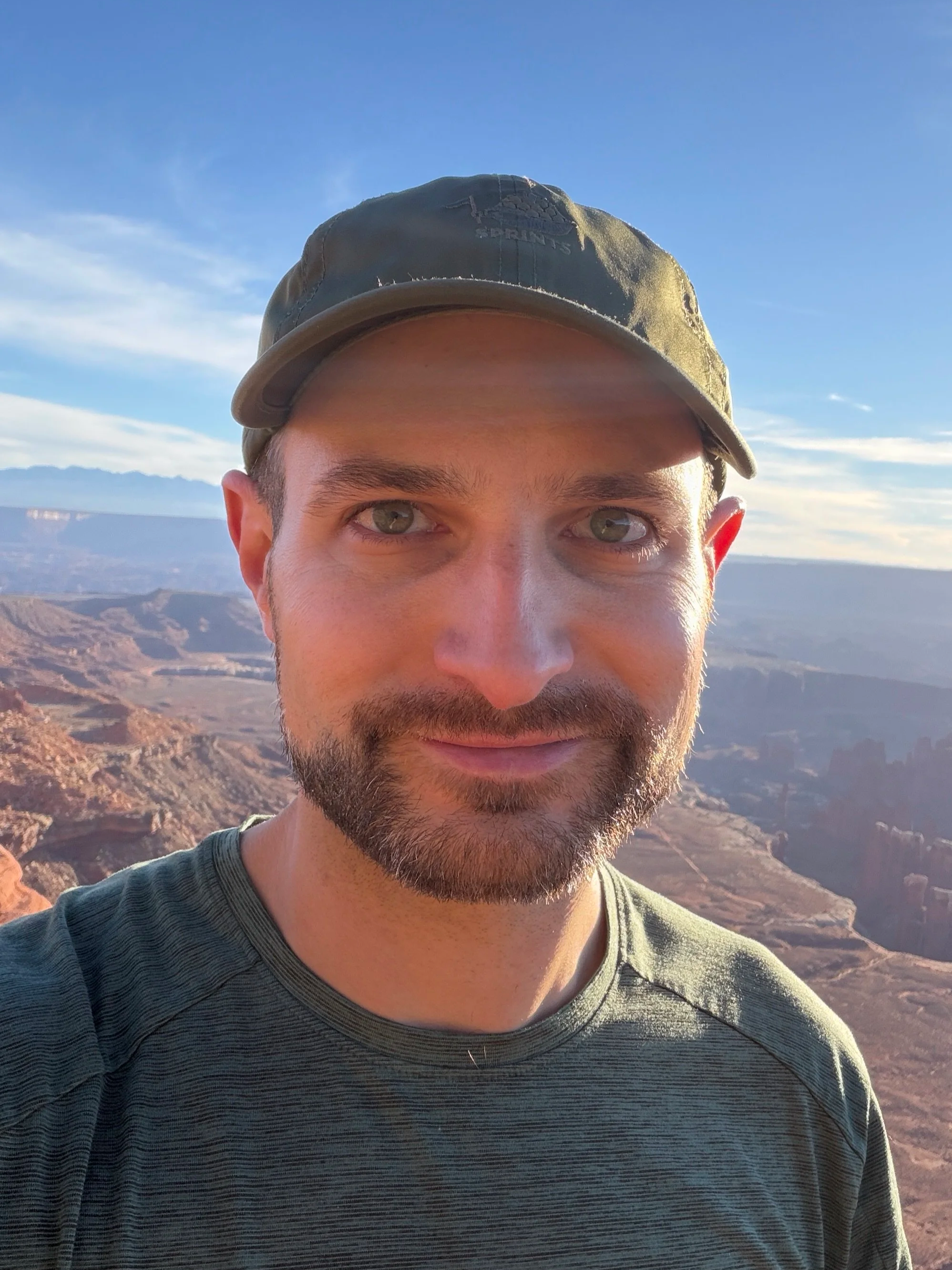 Jared Taylor, organizational psychologist and coach, against a desert landscape with rugged terrain and clear skies in the background.