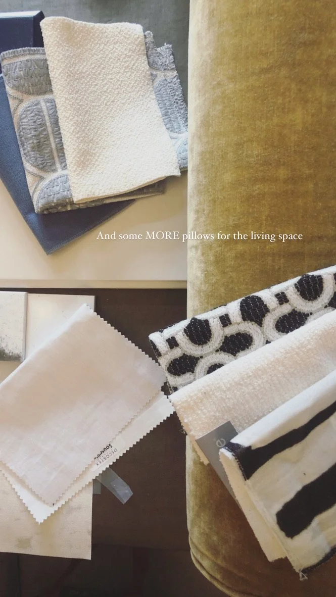 A collection of fabric swatches and pillows with different patterns and textures on a table and an armchair.