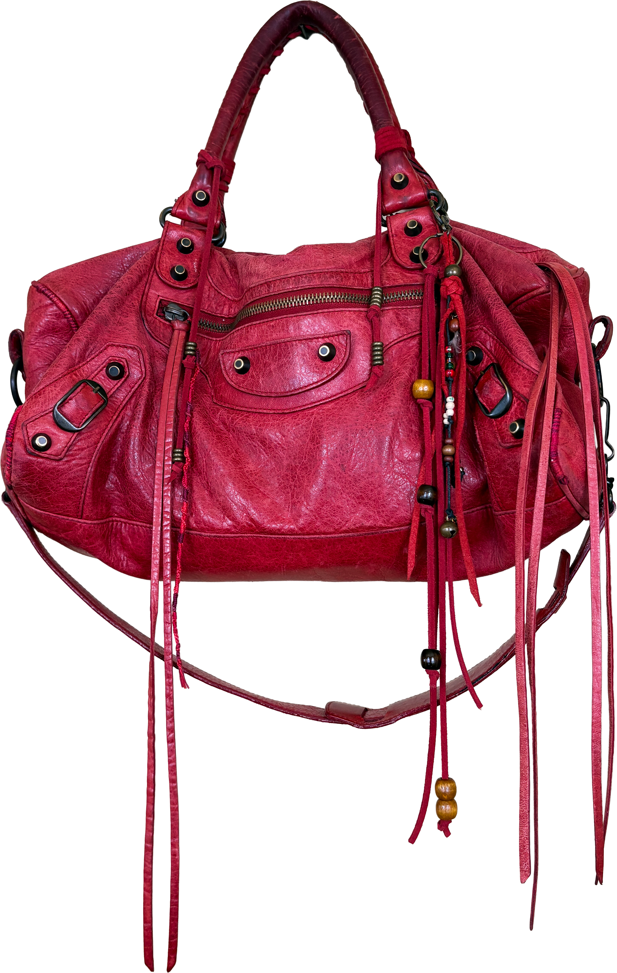 A red leather handbag with multiple pockets, zippers, and decorative beads and straps.