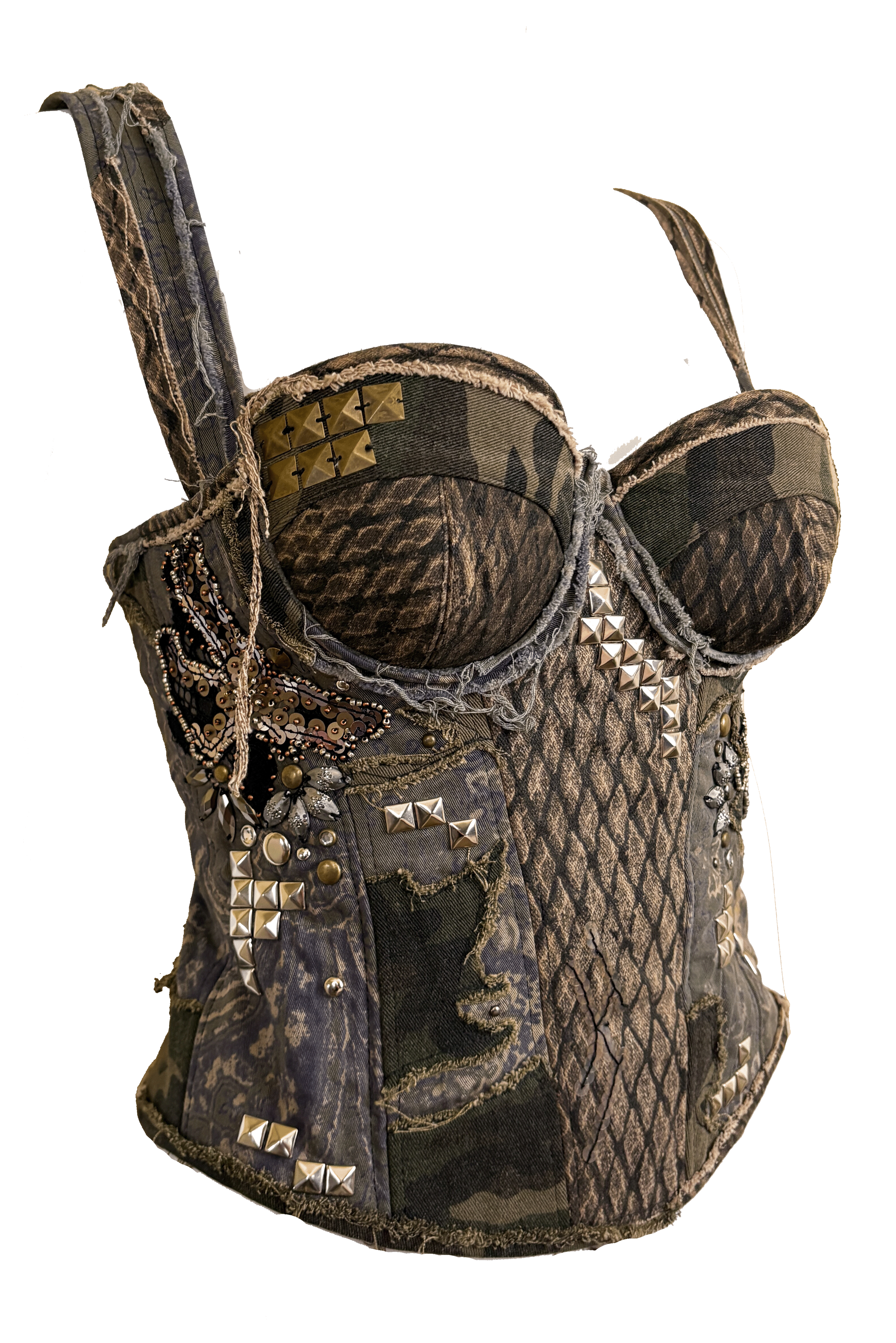 A camouflage bustier decorated with various metal studs, spikes, and embellishments, featuring distressed fabric and faux snakeskin patterning.