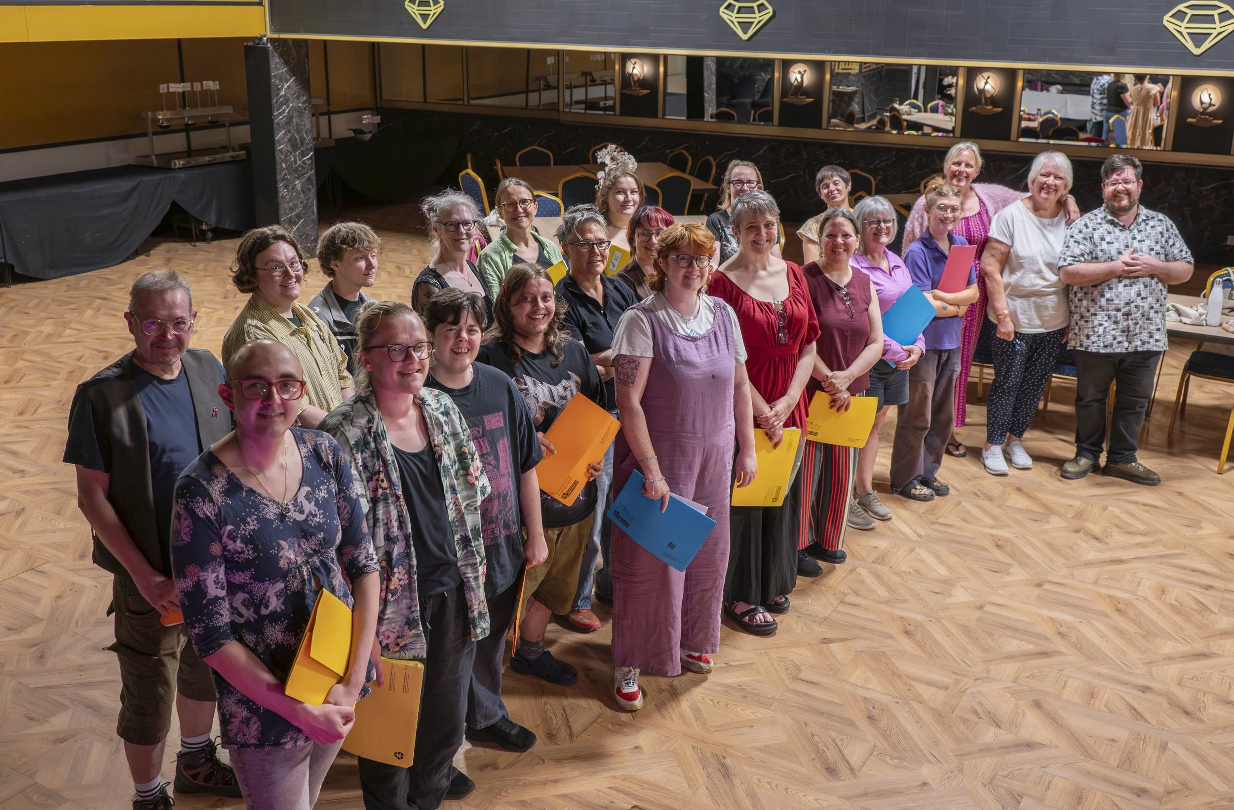 Wyrd Voices members with folders of music in the art deco styled venue