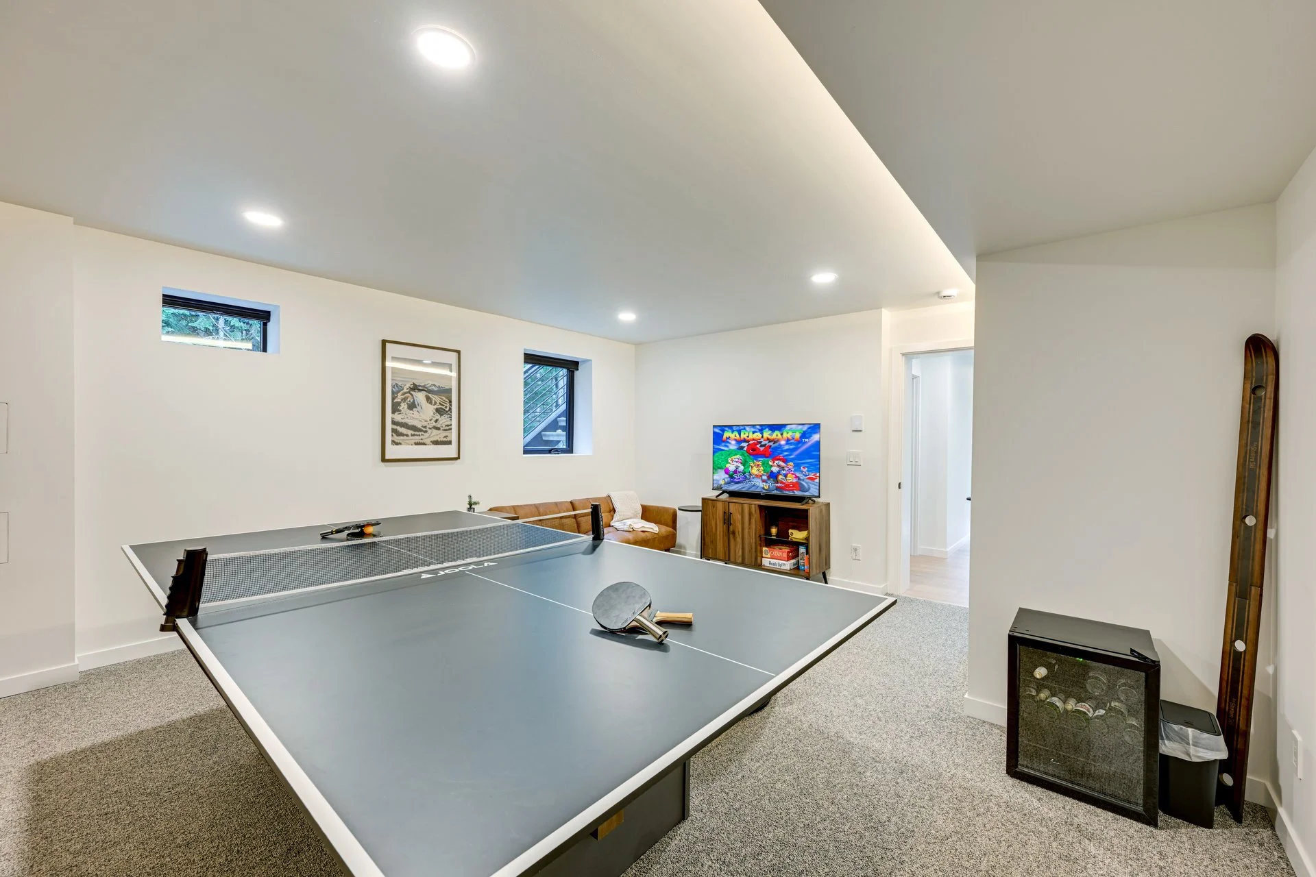 Lumen Field World Cup lodging Airbnb Basement recreation room with ping pong table, small TV, and seating area.