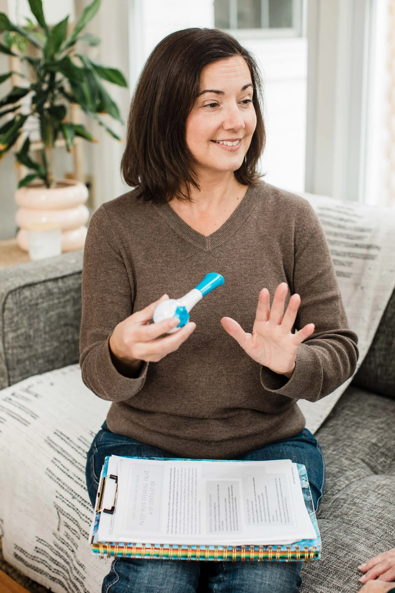 Speech therapist Kristen Calhoun demonstrates a breathing exercise to her senior patient.