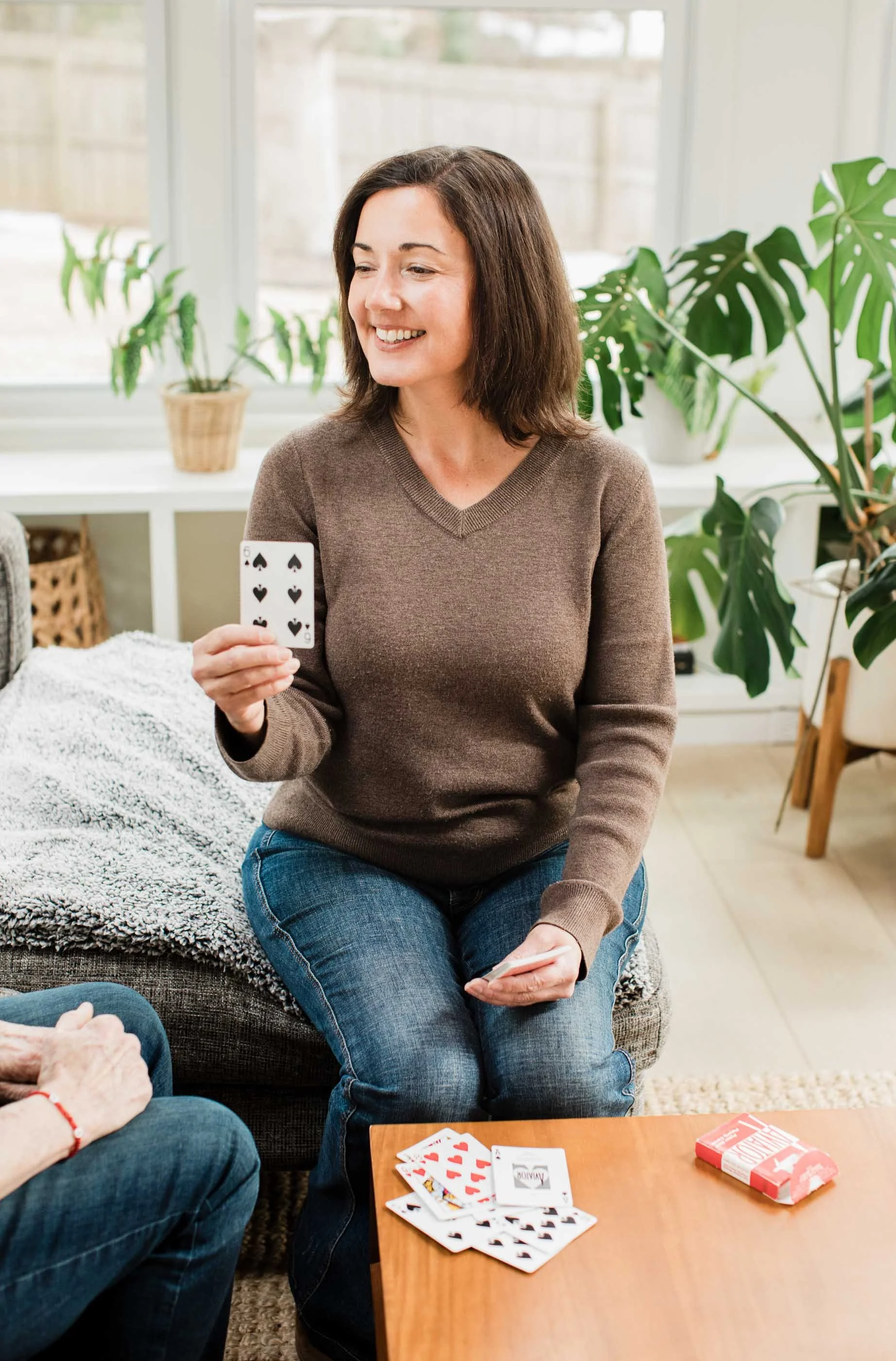 Speech pathologist, Kristen Calhoun, guides a client through a memory exercise using a deck of playing cards in a light filled room.