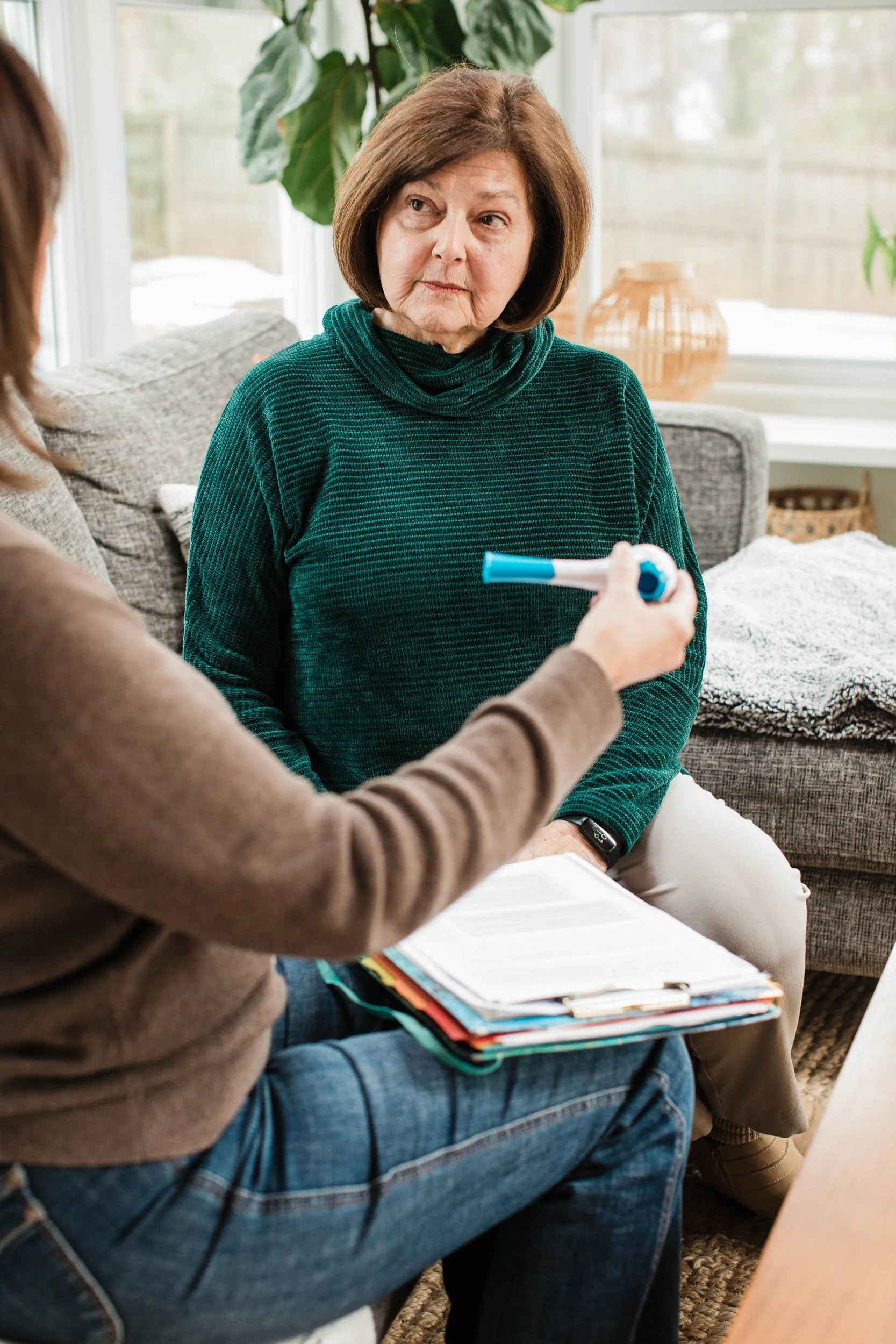 Senior woman in Greenville, SC, intently listens to her speech therapist during a session.
