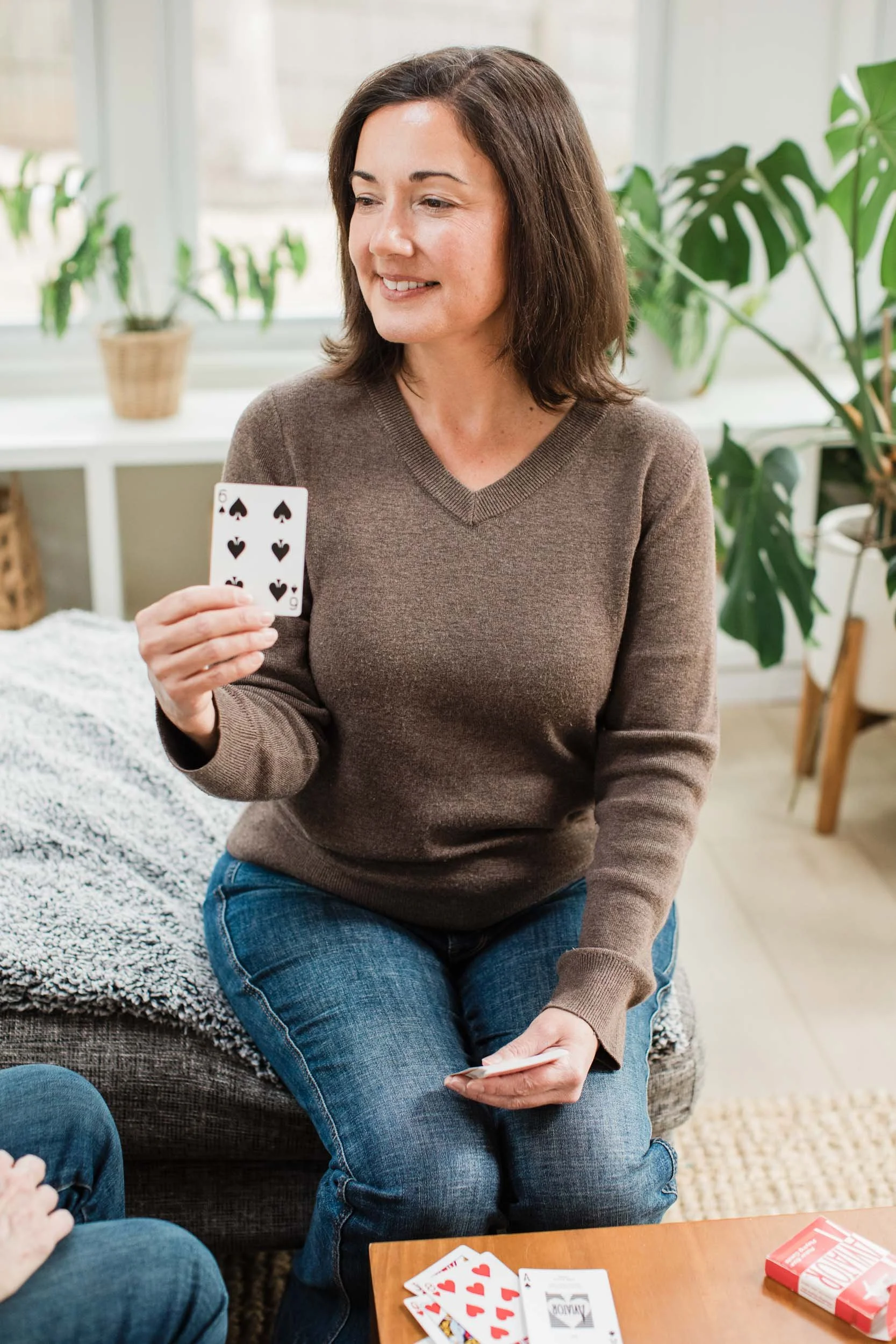 Kristen Calhoun, a speech therapist, guides a patient through a cognitive exercise using a colorful deck of cards.