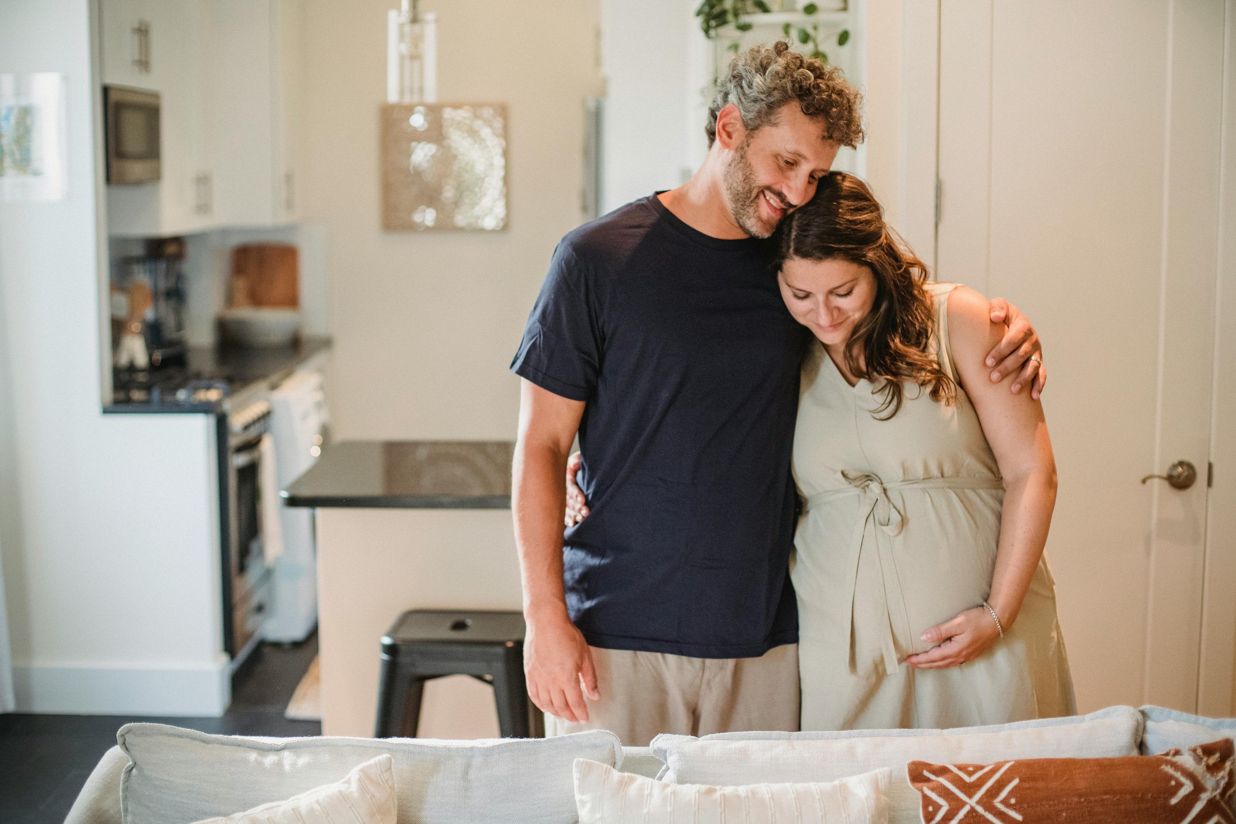 Couple embracing during pregnancy at home — partner support during perinatal period.