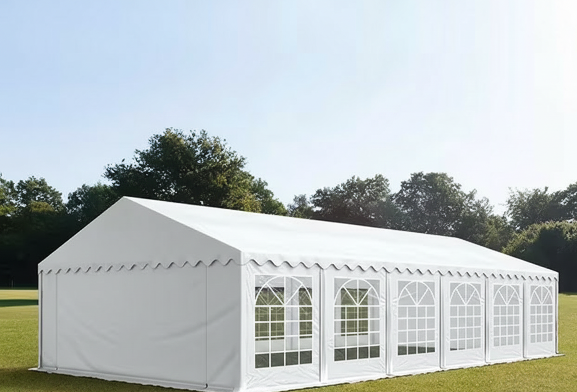 Carpa blanca grande en un campo verde con árboles al fondo.