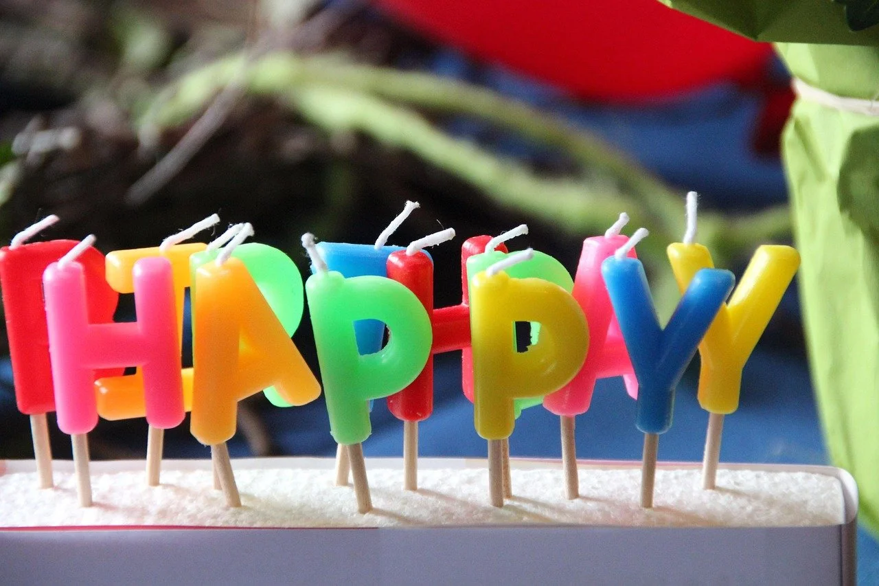 Colorful birthday candles spelling out 'HAPPY' on a birthday cake.