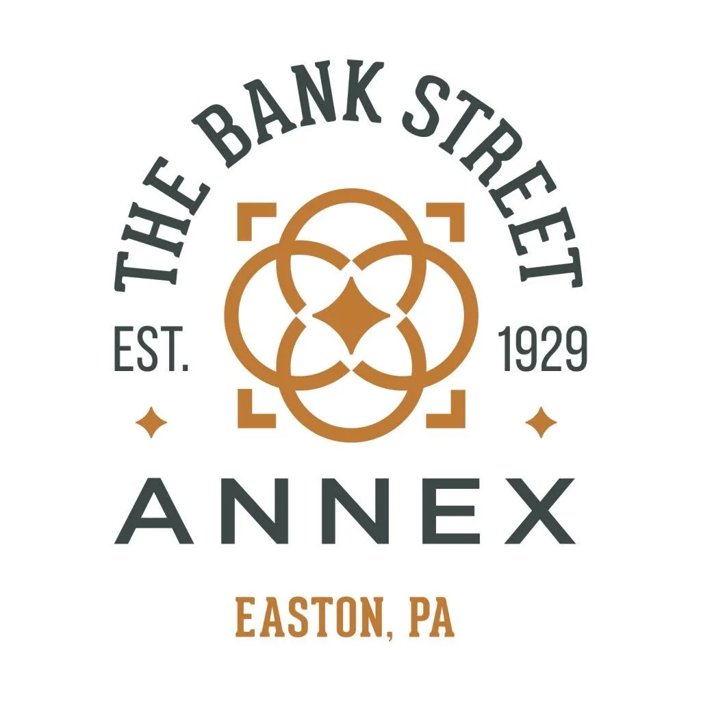 Logo for The Bank Street Annex in Easton, PA, established in 1929, featuring decorative gold geometric shapes and black text.