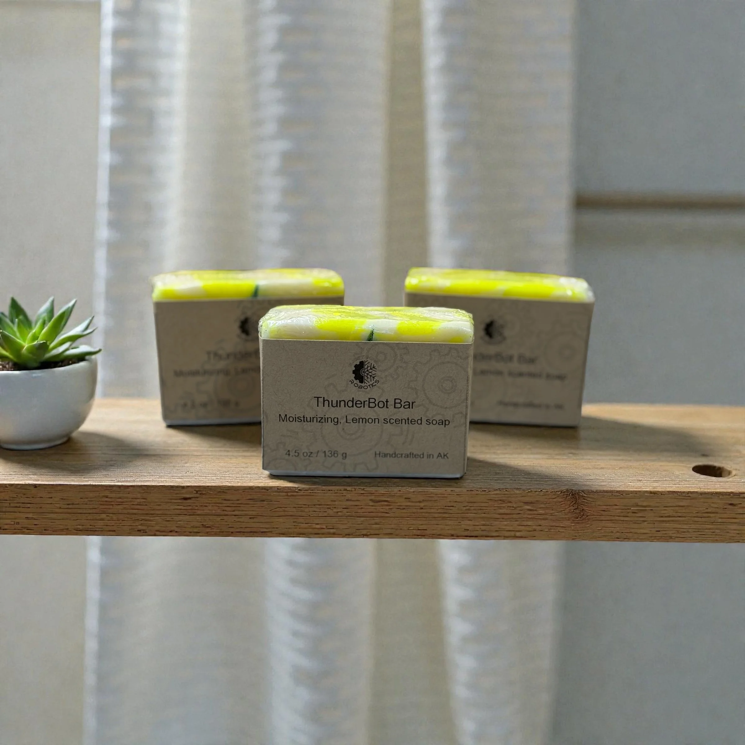 Three bars of yellow and white swirled bars of soap wrapped in brown paper sitting on a wooden shelf.