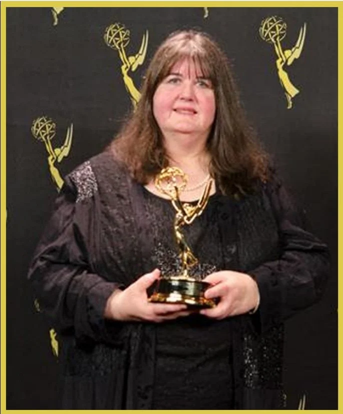 A photo of Linda Giannecchini receiving and Emmy Award.
