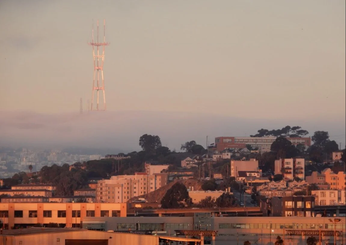 An image of Sutro Tower looming over a fog bank in San Francisco, as viewed from Twin Peaks.