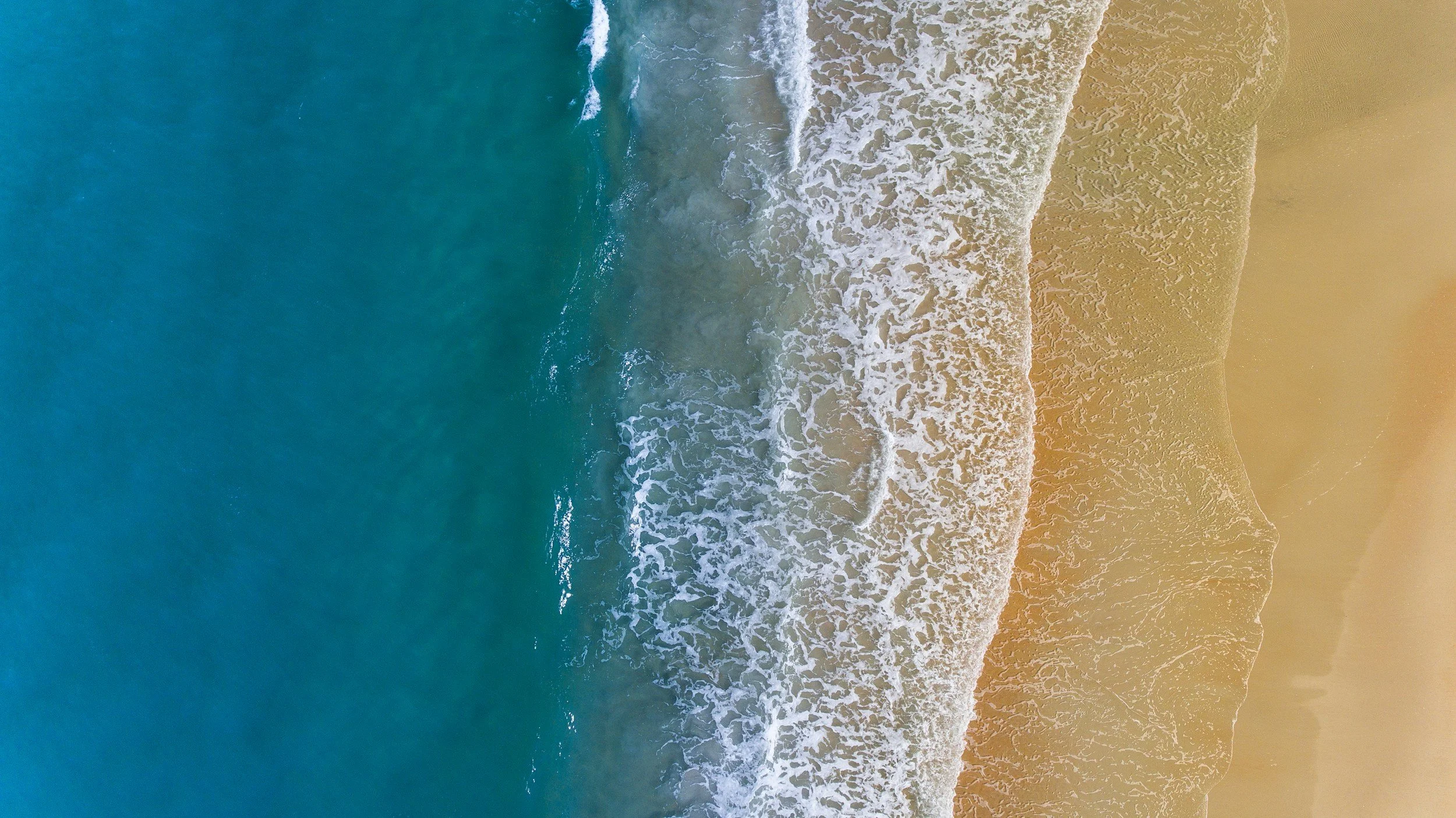 a beach overhead shot where water meets sand