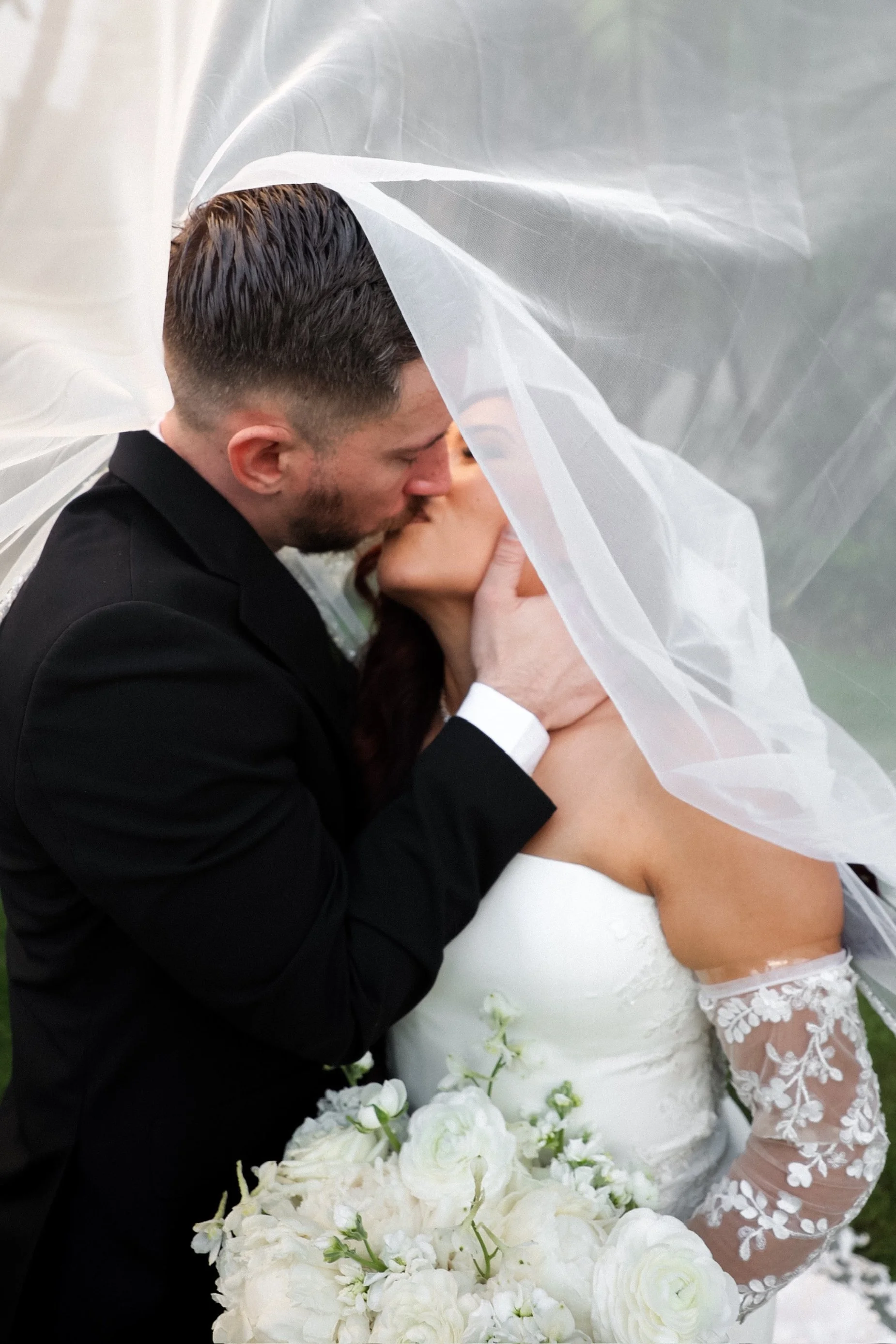 bride and groom kiss under veil.jpg
