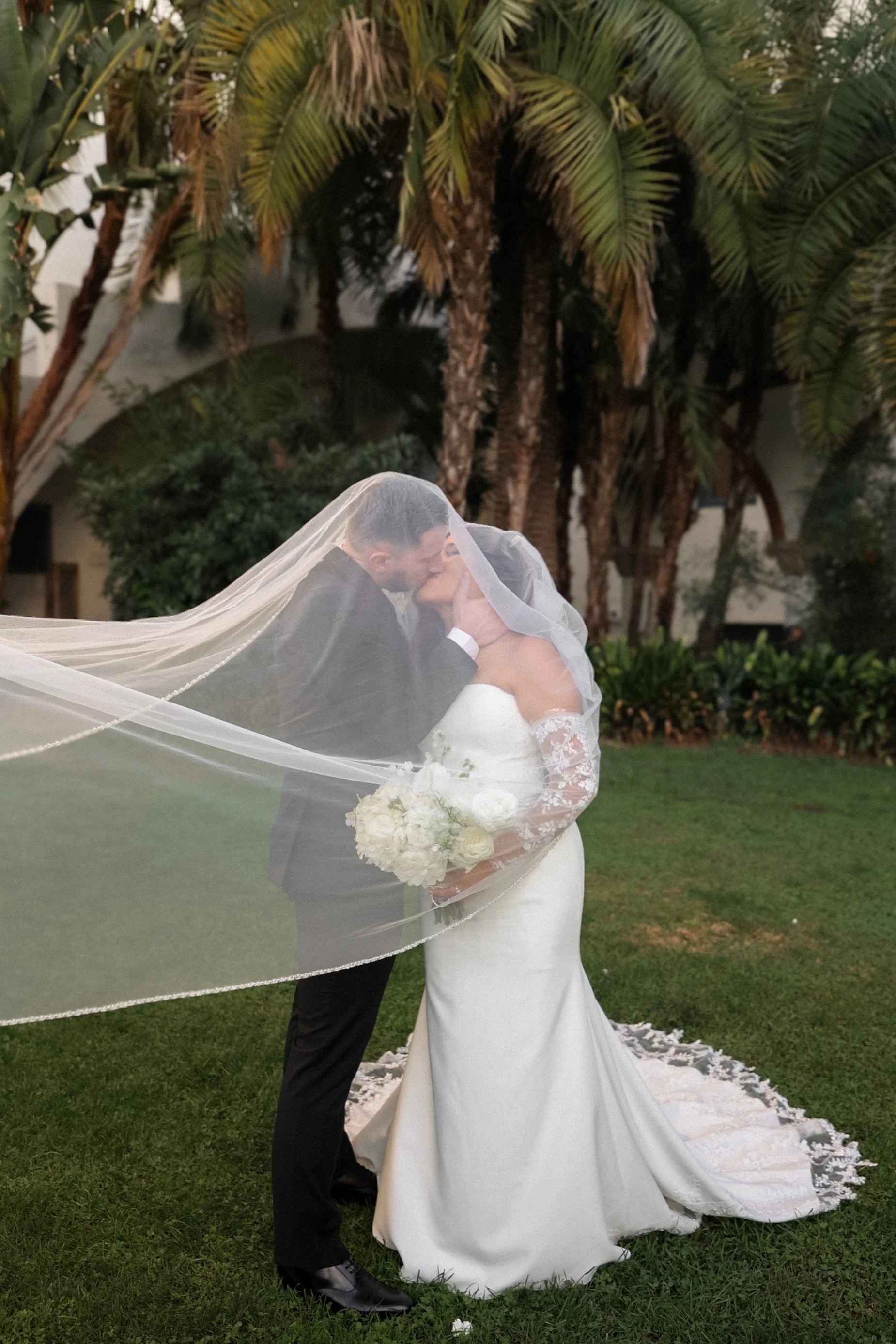 groom kissing his bride under veil.jpg