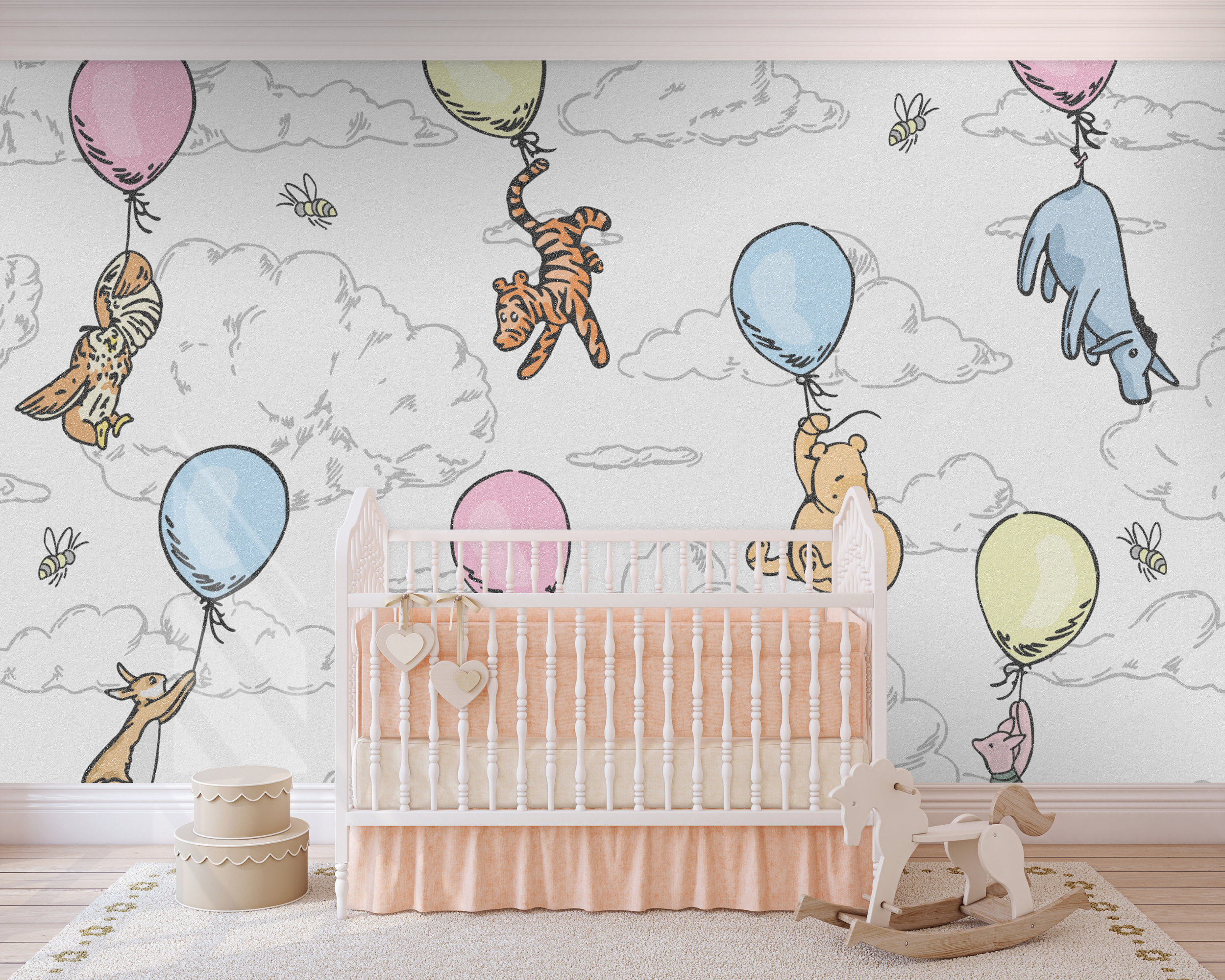 Nursery with wall mural featuring clouds, balloons, animals, and bees, white crib with peach bedding, wooden rocking horse, and beige storage bins.