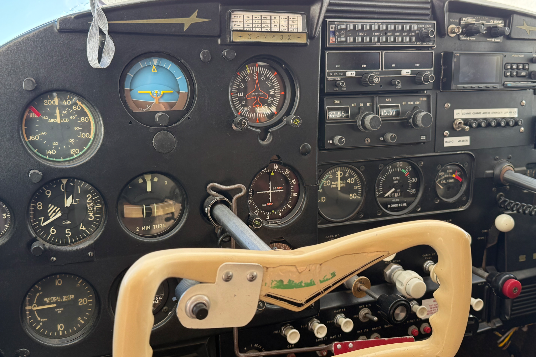 Close-up of an aircraft cockpit instrument panel with various gauges, switches, and controls.