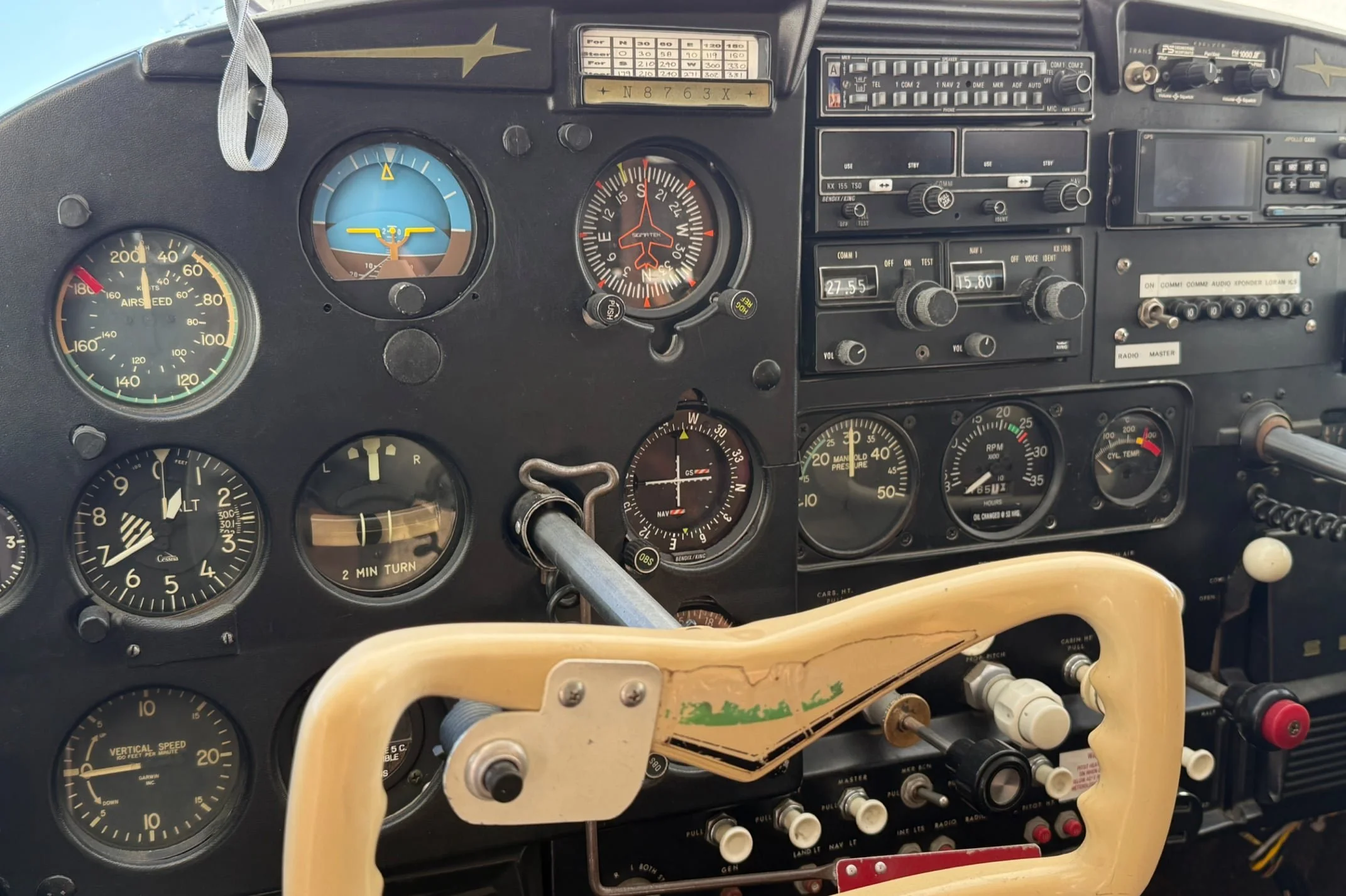 Close-up of an aircraft cockpit instrument panel with various gauges, switches, and controls.
