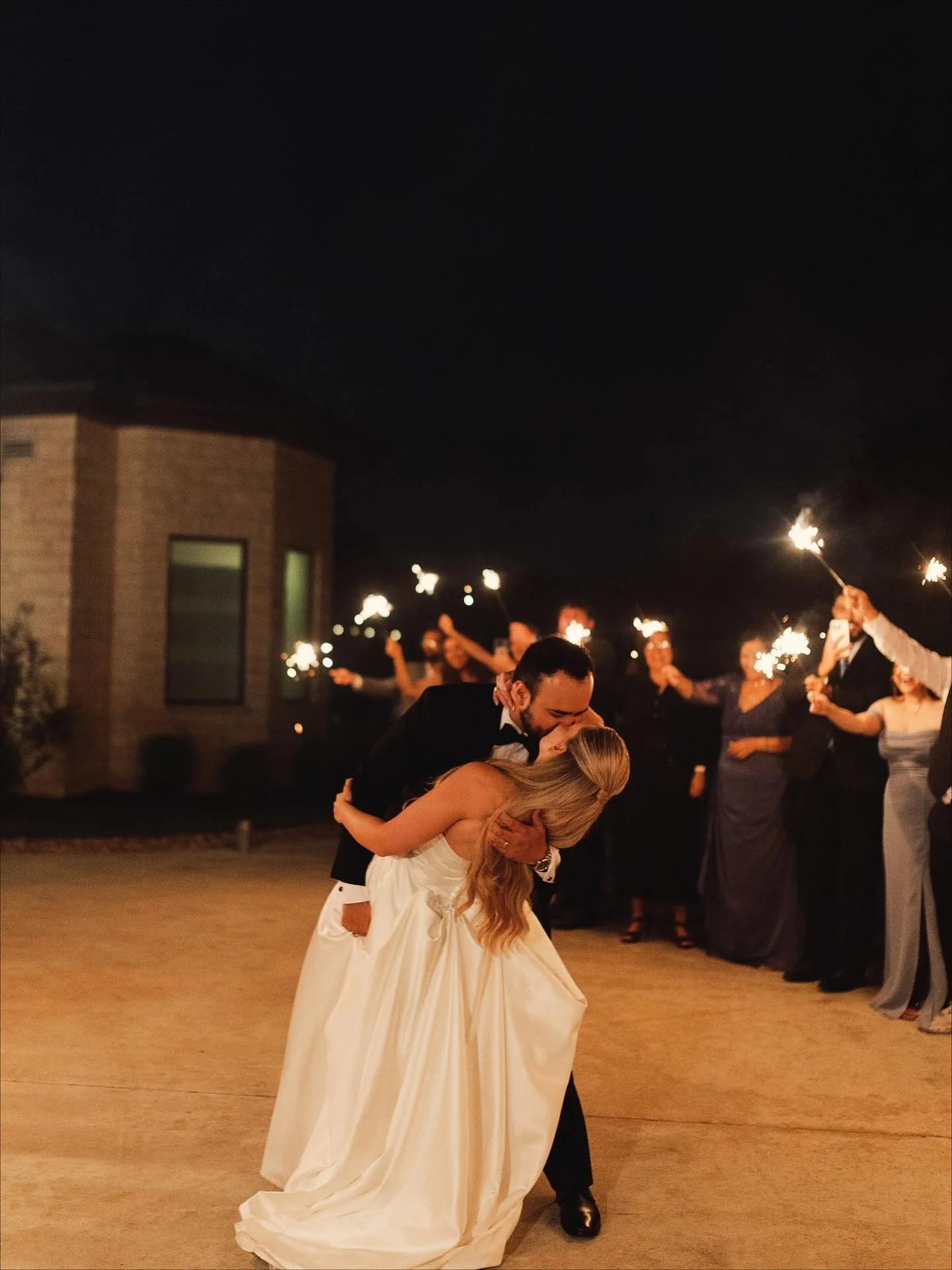 A bride and groom sharing a kiss during their wedding catered by Gourmet Gals Catering in Texas.