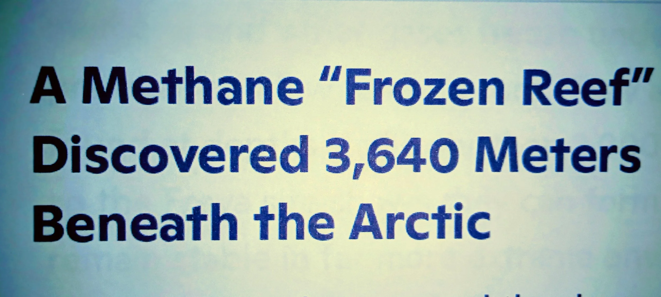 Text on a screen that reads 'A Methane "Frozen Reef" Discovered 3,640 Meters Beneath the Arctic'.