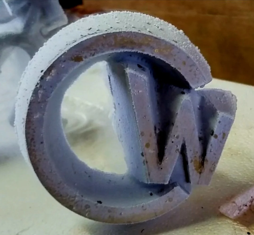 Close-up of a metal freeze brand 'CW'. It is owned by Clay West of CW Elite Cow Horses.
