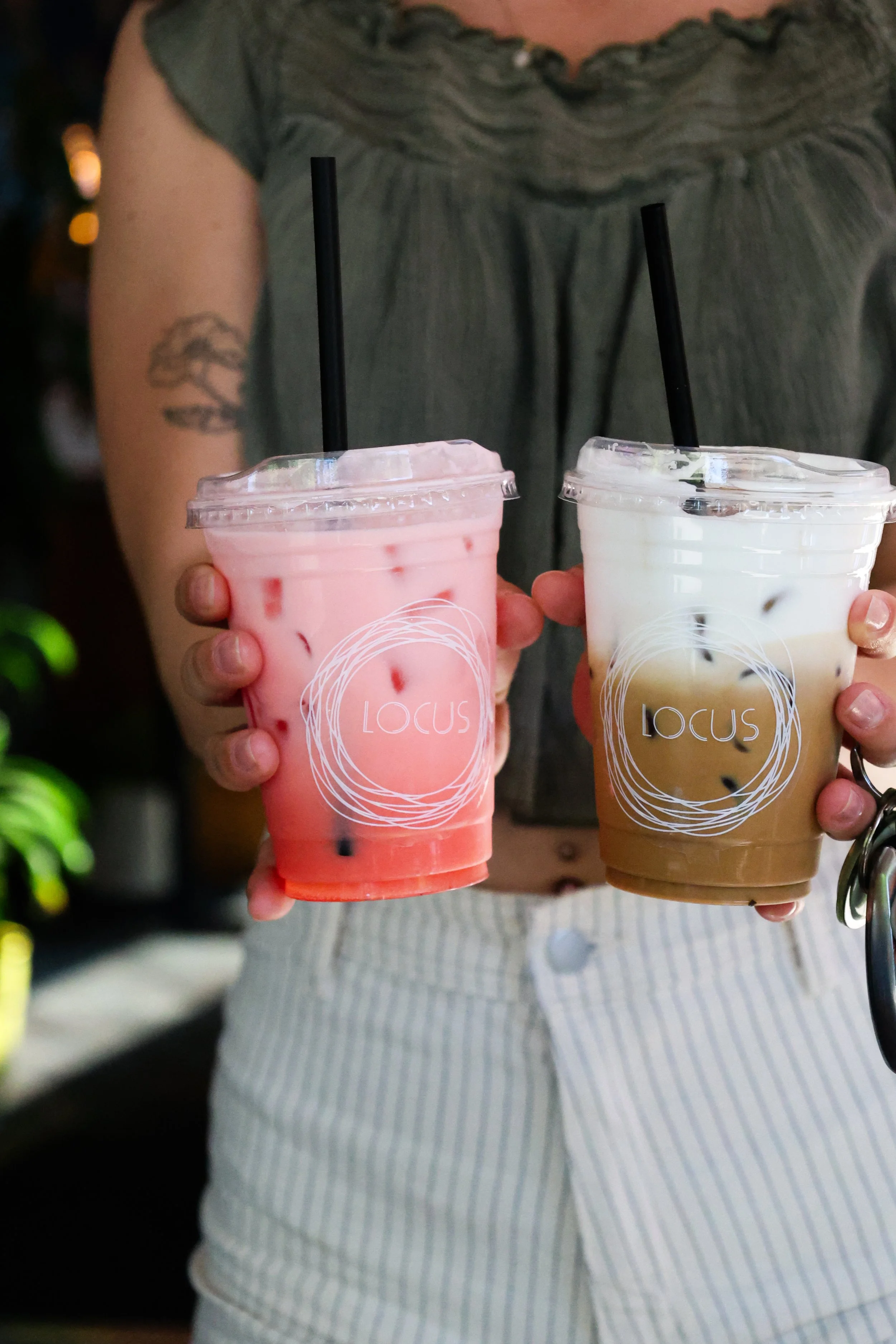 Two iced drinks held up at Locus coffee and taproom in downtown Bellingham WA