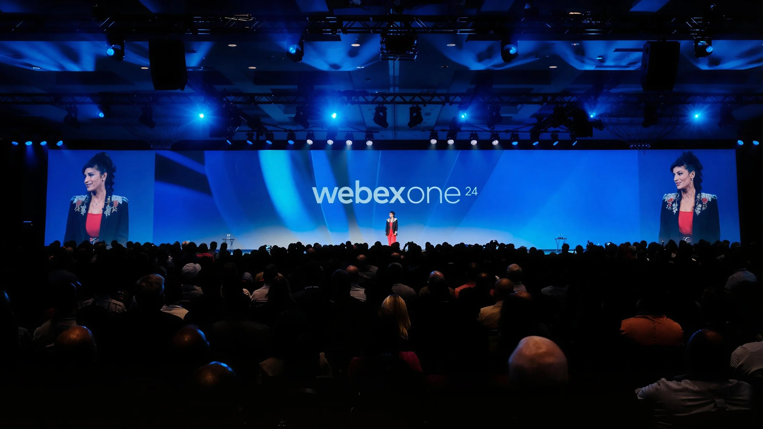 Speaker presenting to a full audience at the WebexOne 2024 keynote.