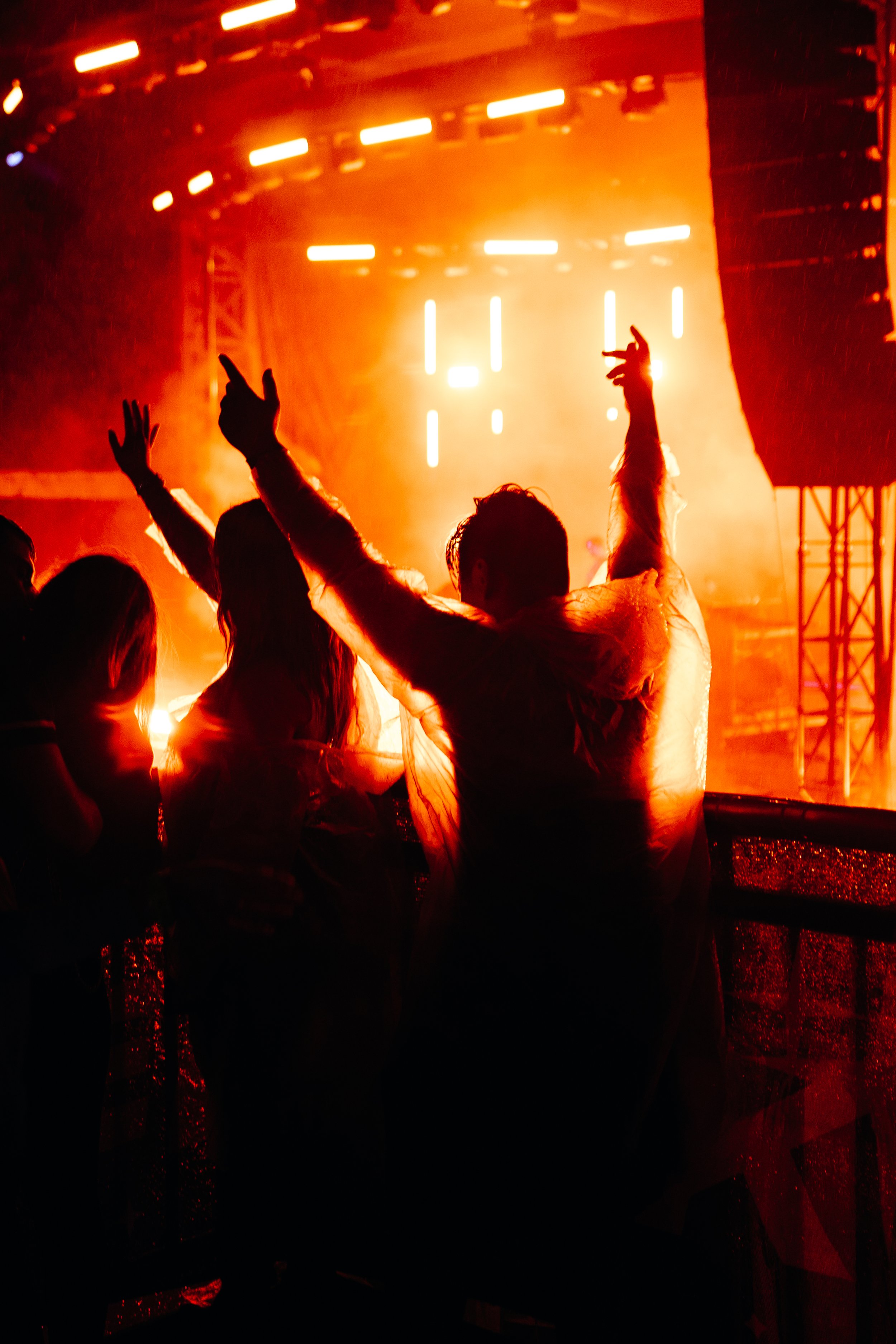 People dancing at a concert with bright orange stage lights