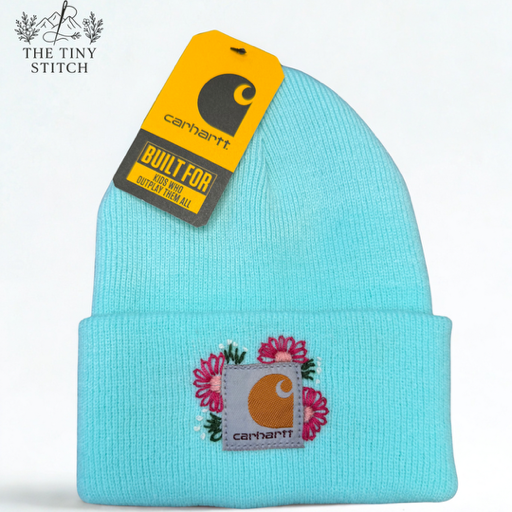 Light blue Carhartt beanie with embroidered flowers and a Carhartt logo patch on the front, attached to a yellow Carhartt tag.