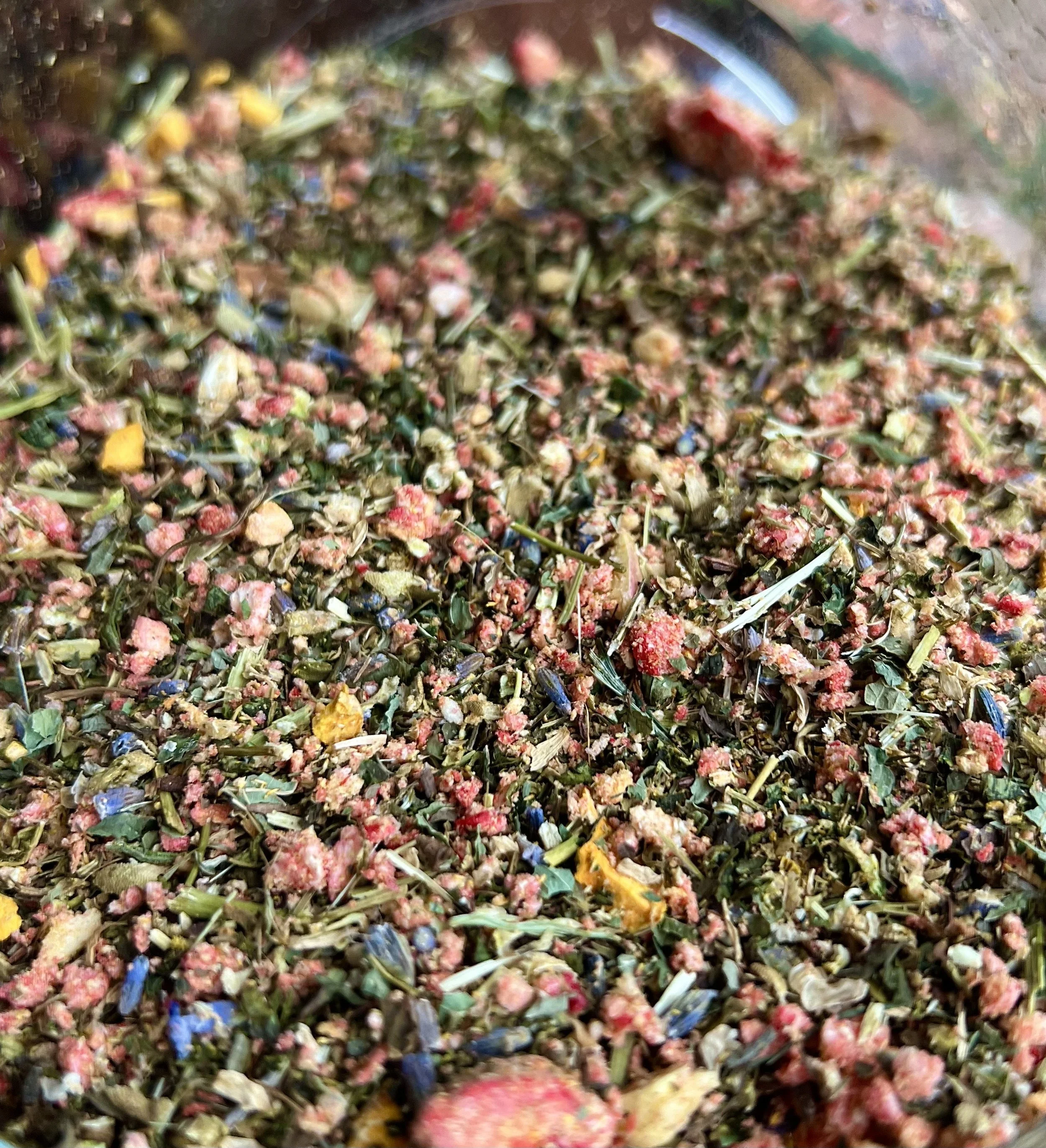 Close-up of a mixture of dried herbs, flowers, and plant materials, possibly for herbal tea or cooking.