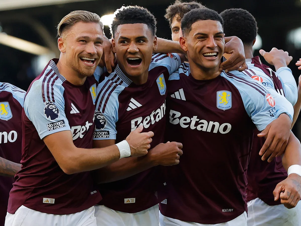 A group of soccer players wearing maroon and sky blue jerseys celebrating together on the field.
